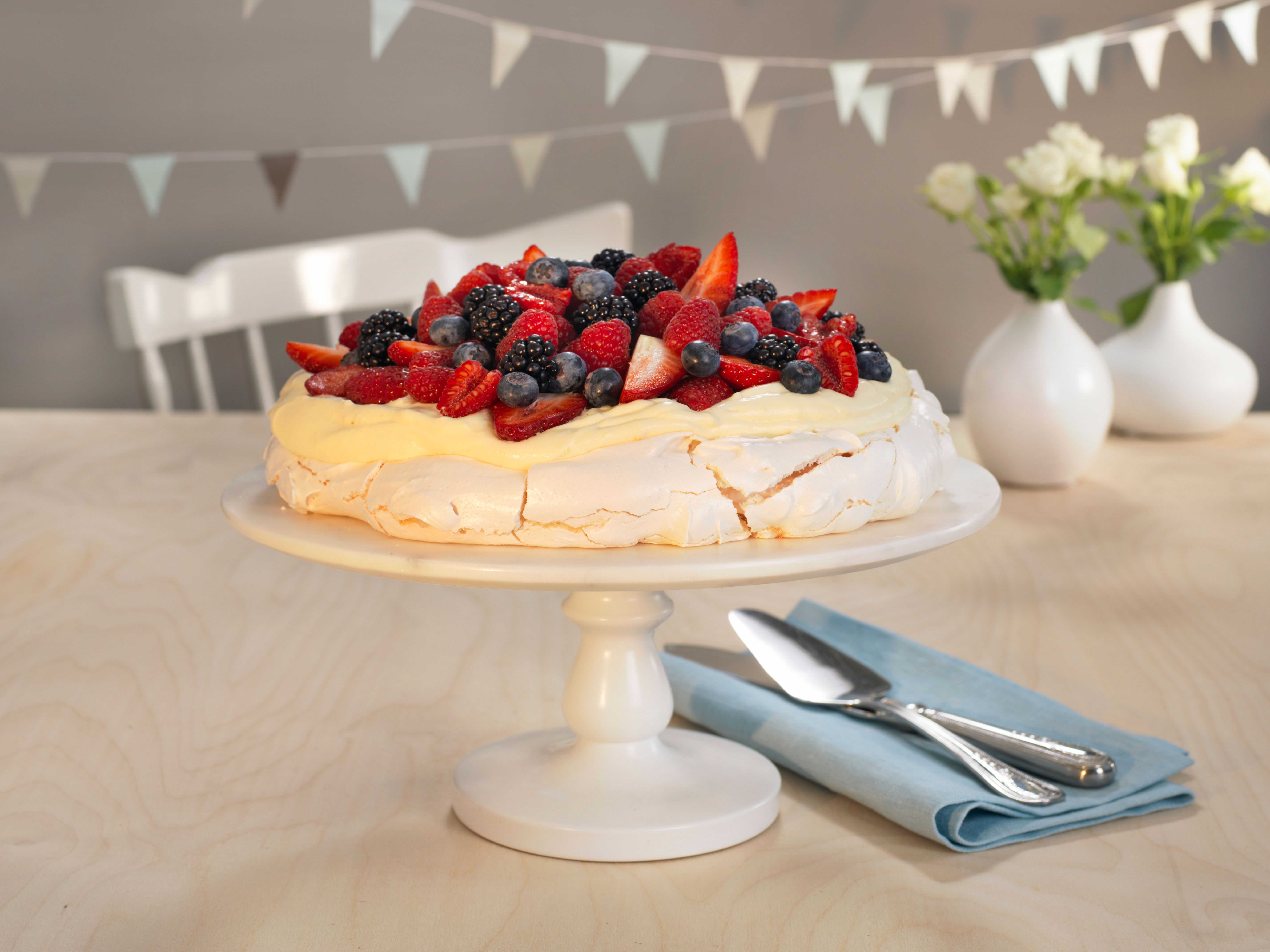 A pavlova decorated with fresh berries