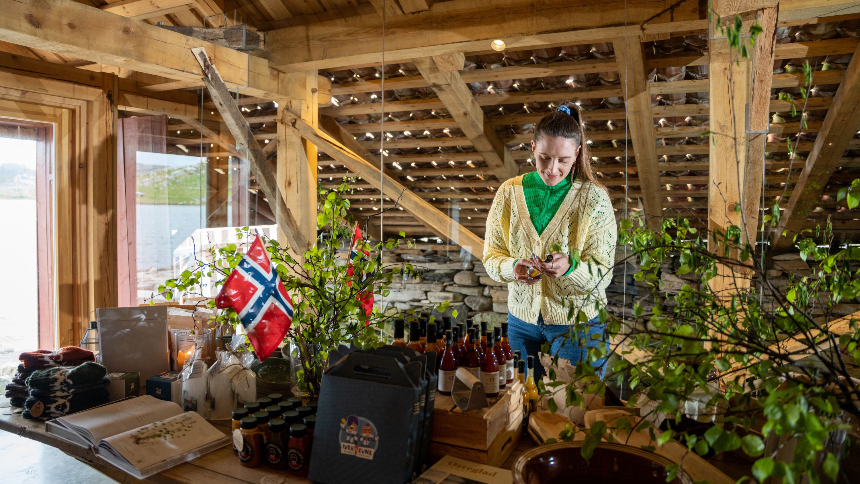 A woman looking at local products at a farm shop at Utstein farm in the Stavanger Region, Fjord Norway.