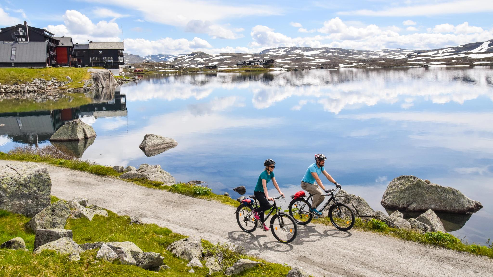 Two people on bikes next to a lake