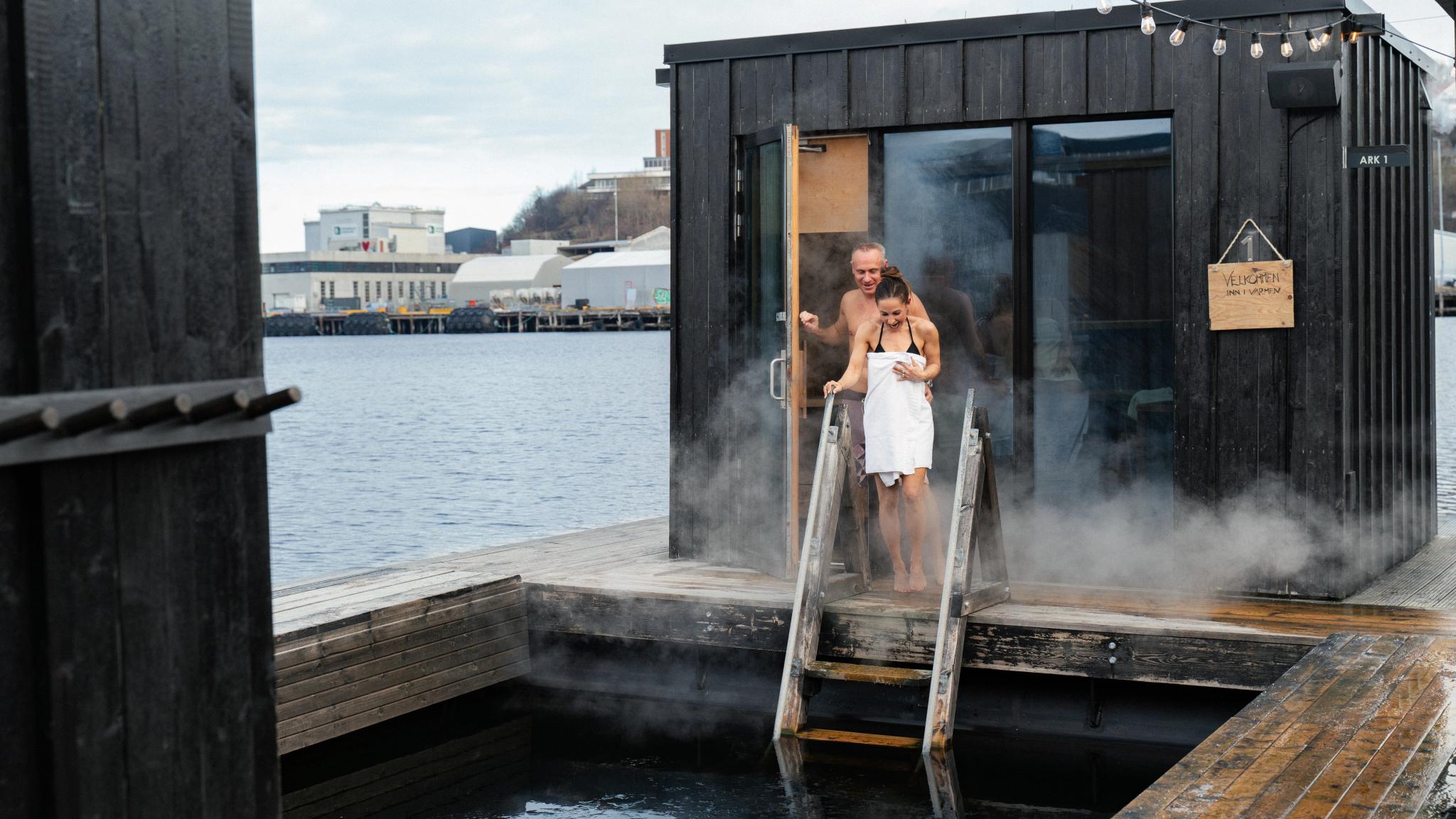 A man and a woman heading out from a steaming hot sauna into a chilling batch in Trondheim