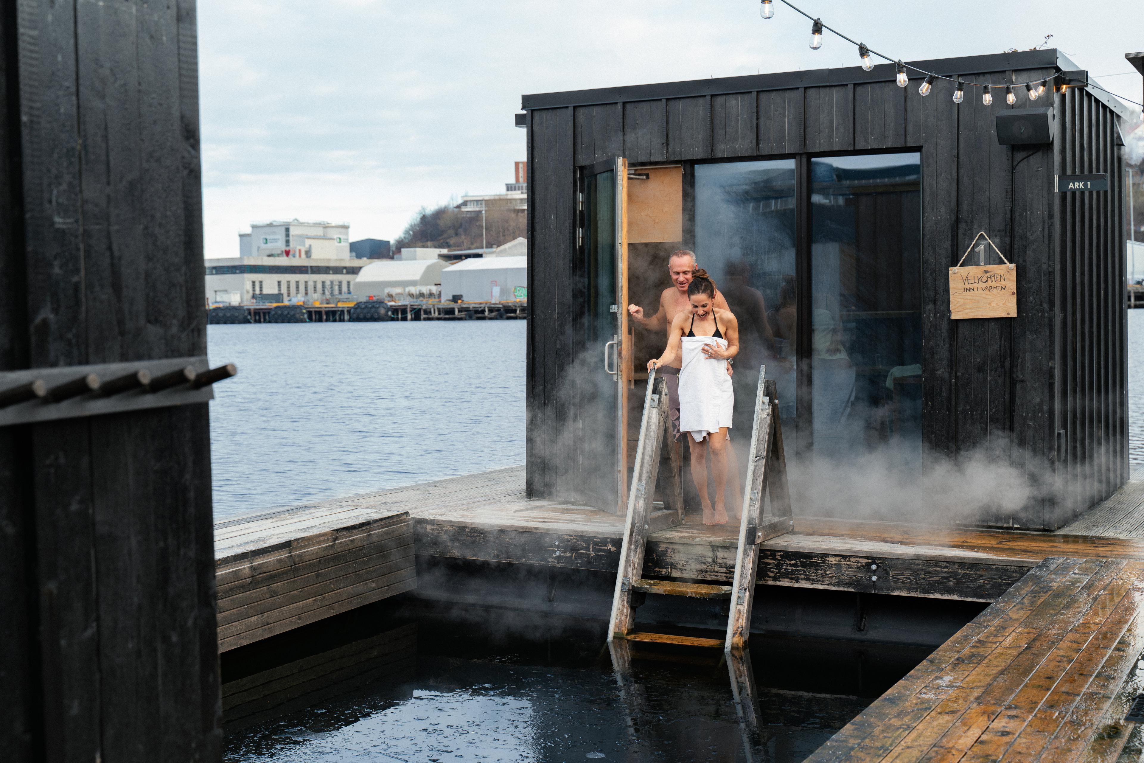 A man and a woman heading out from a steaming hot sauna into a chilling batch in Trondheim