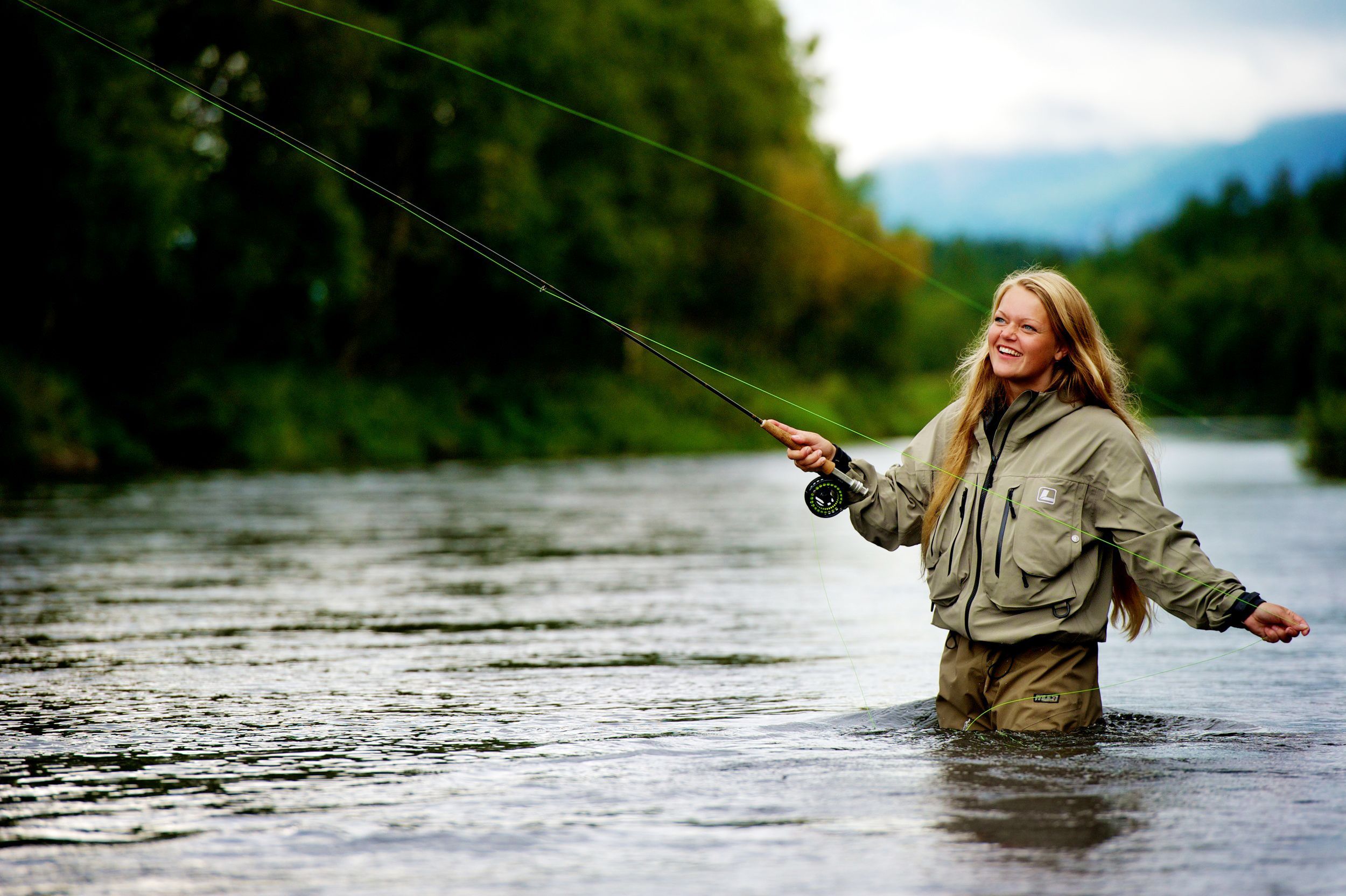 Girl smiling as she is fly fishing in Hemsedal in Eastern Norway