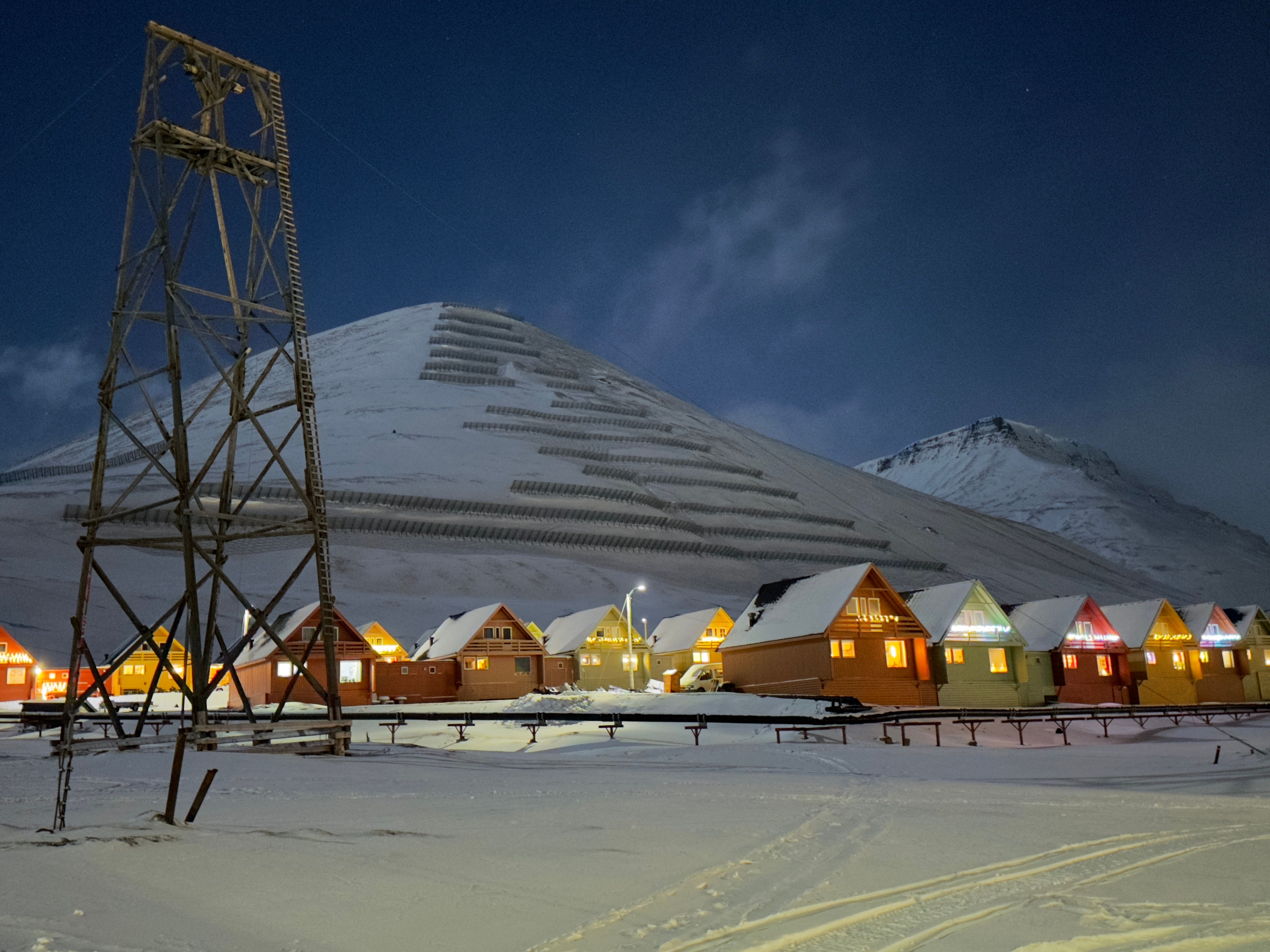 Tiny houses in front of a big mountain in winter