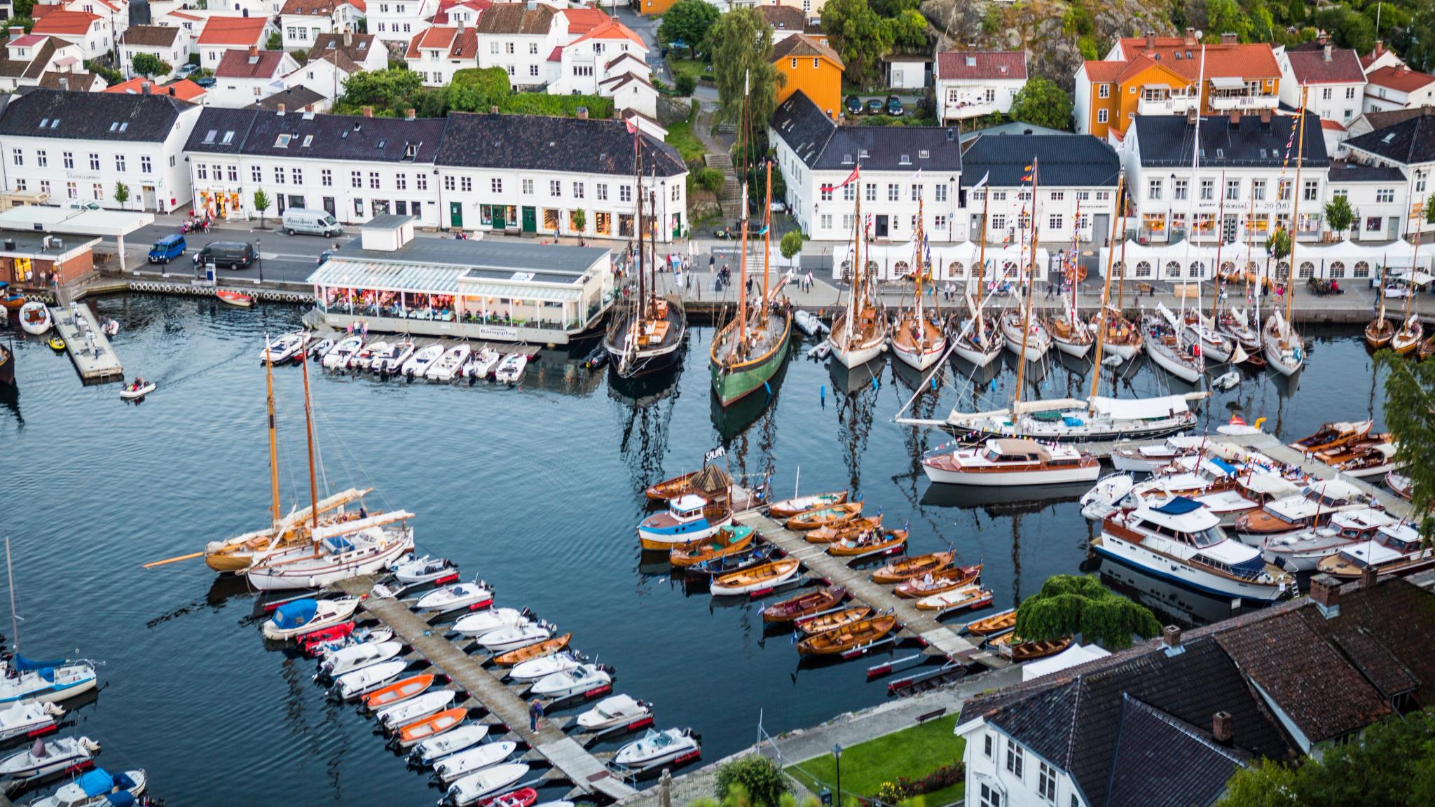 Båter i Risør havn, hvitmalte hus i bakgrunnen