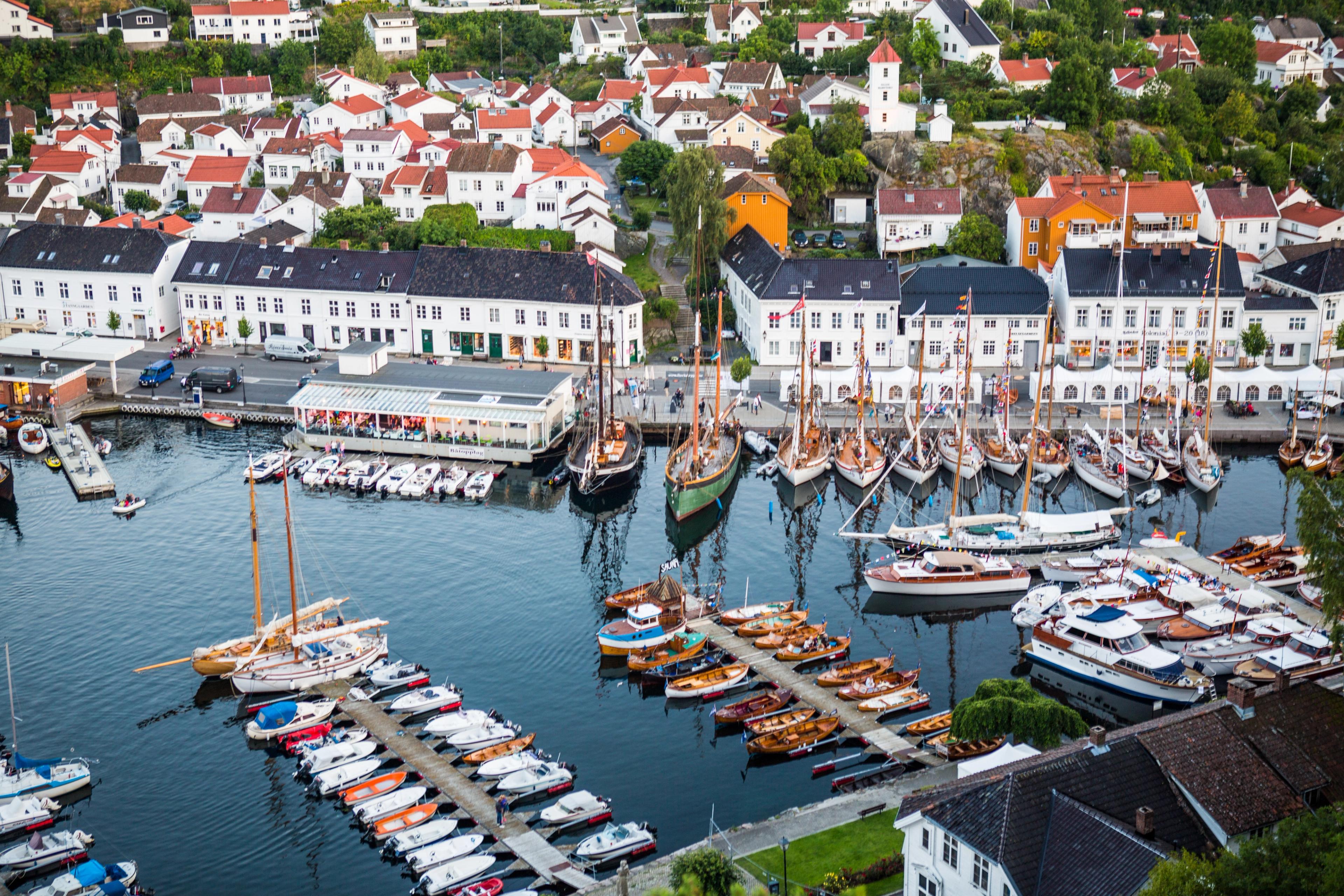 Boats in Risør harbour with white-painted houses in the background