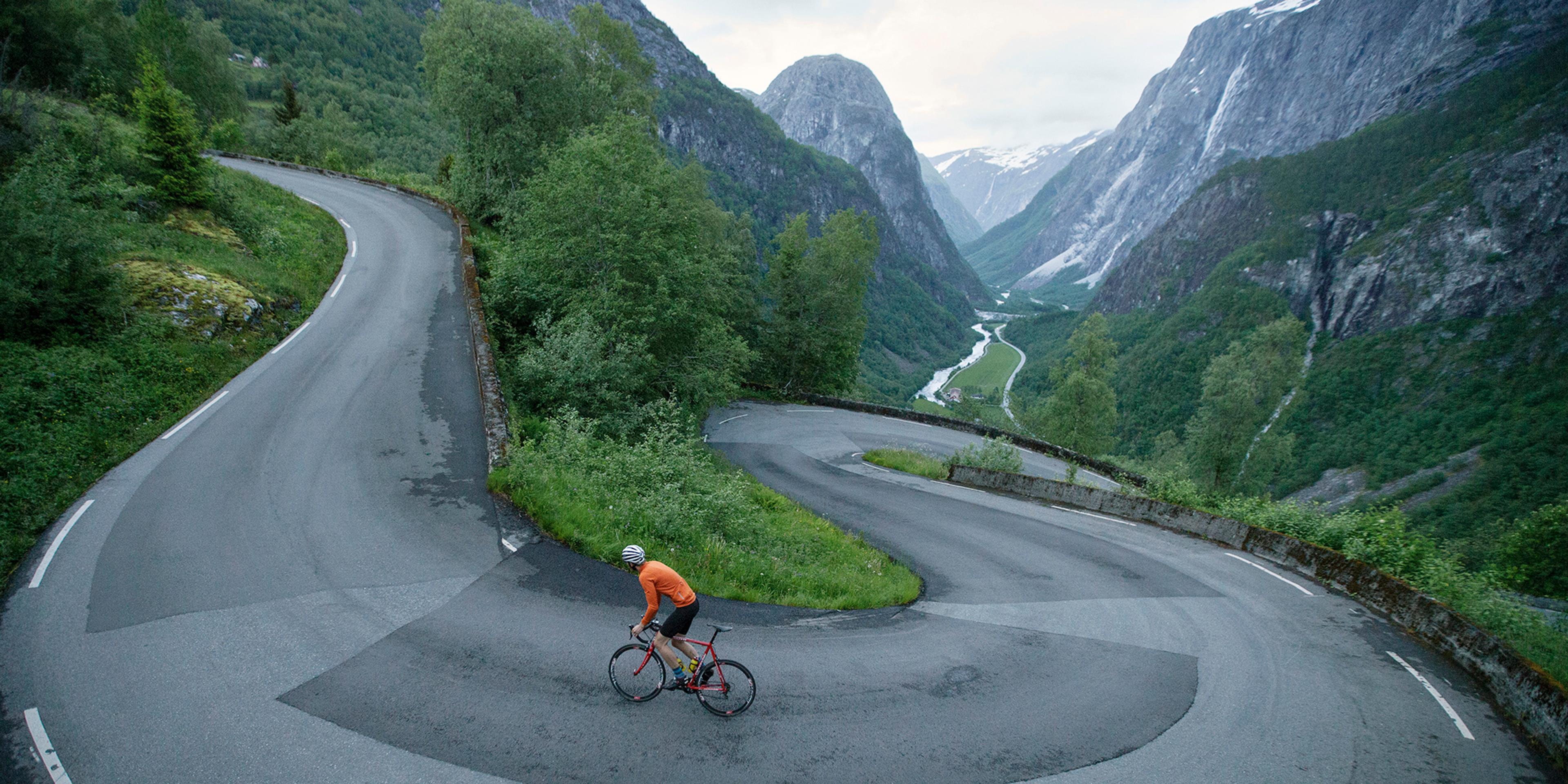 En person cykler op ad landevejen Stalheimskleiva i Voss, Norge - en top 5 cykelrute i de norske fjelde