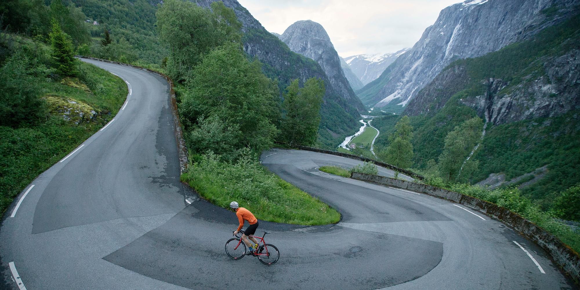 En person cykler op ad landevejen Stalheimskleiva i Voss, Norge - en top 5 cykelrute i de norske fjelde