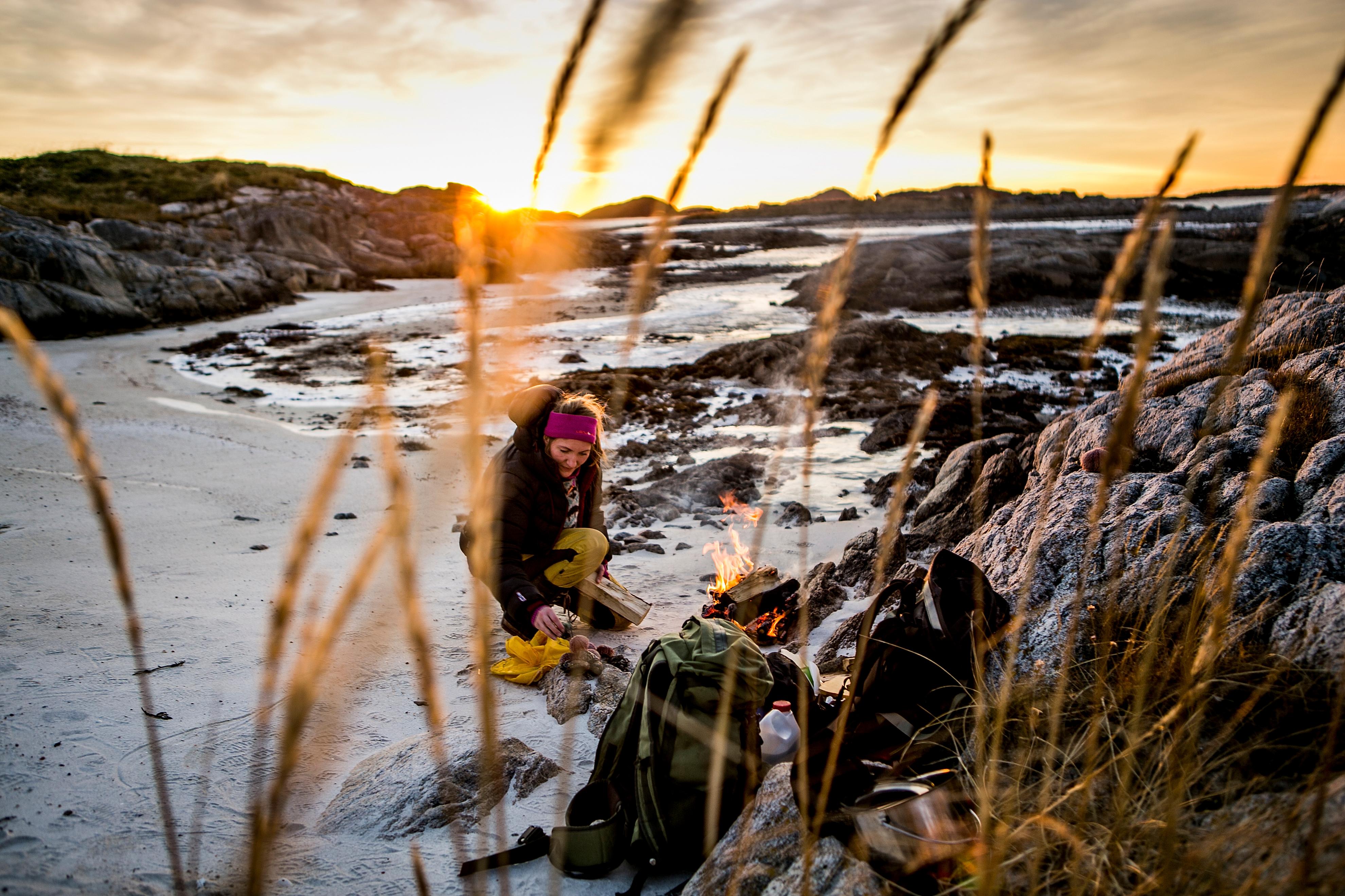 En dame lager mat på stranden i Steigen i Nordland, Nord-Norge