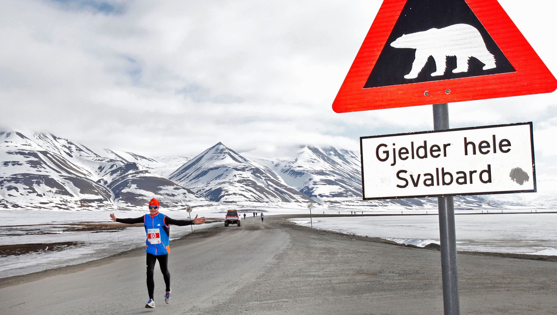 En maratonløper passerer et isbjørnskilt på Spitsbergen, Svalbard