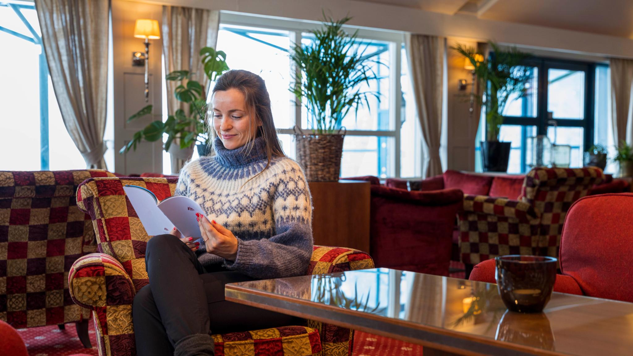 Kvinne leser i lobbyen på Hotell Union