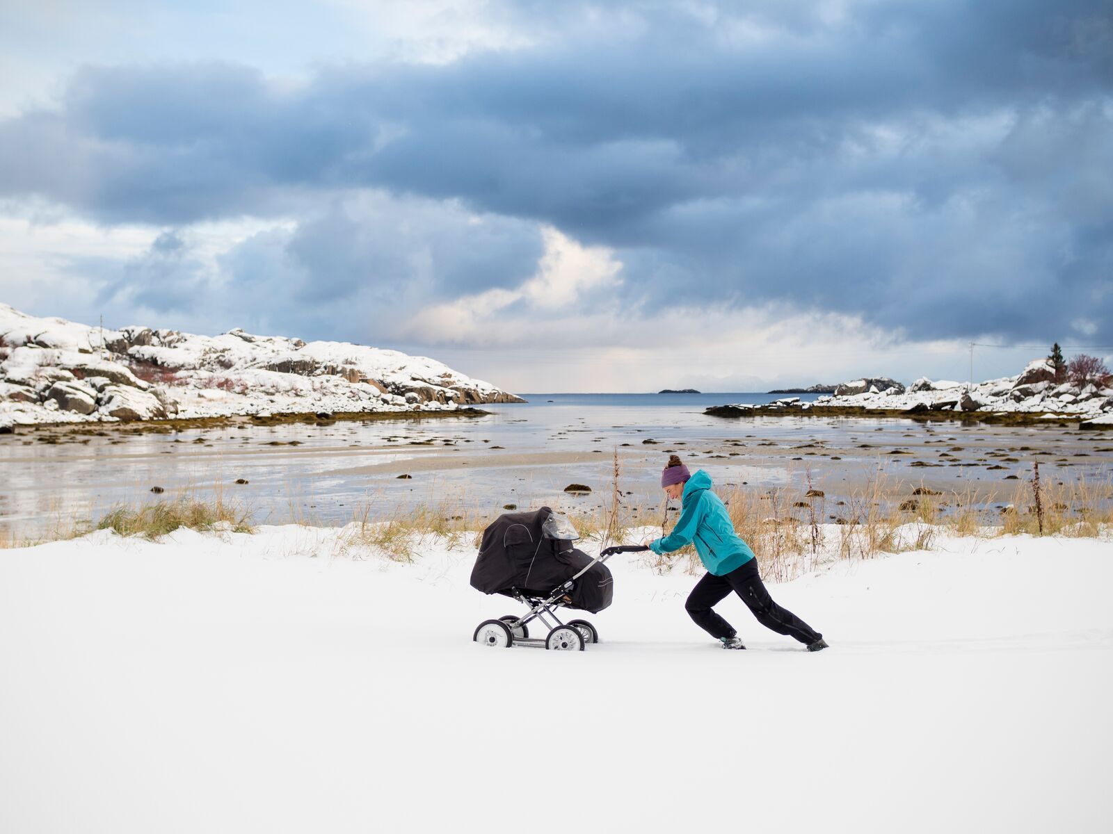 Woman pushing a pram in the snow in Northern Norway