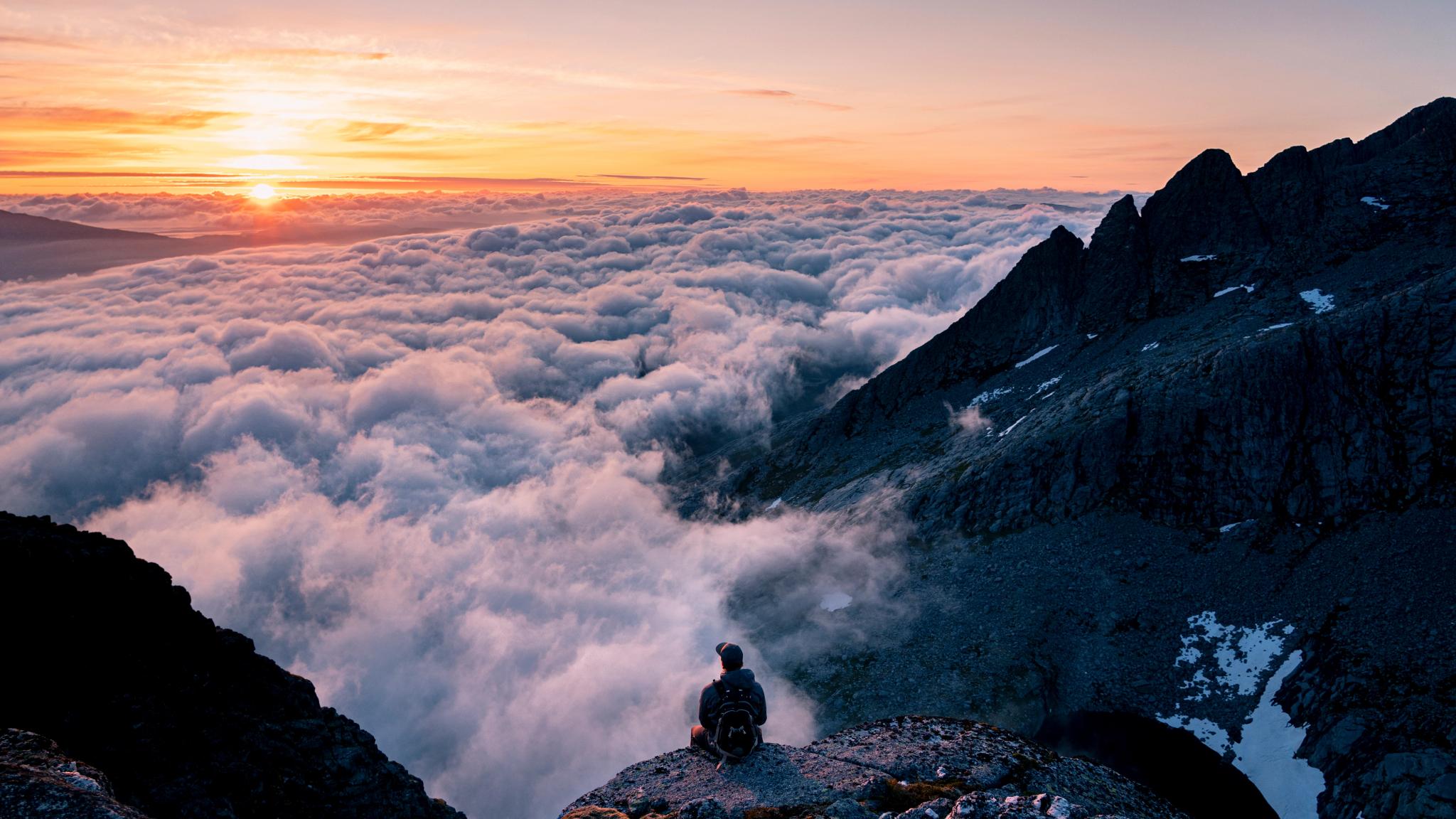 Person sitting at the top of the seven sisters hike in Gryfoten, Northern Norway