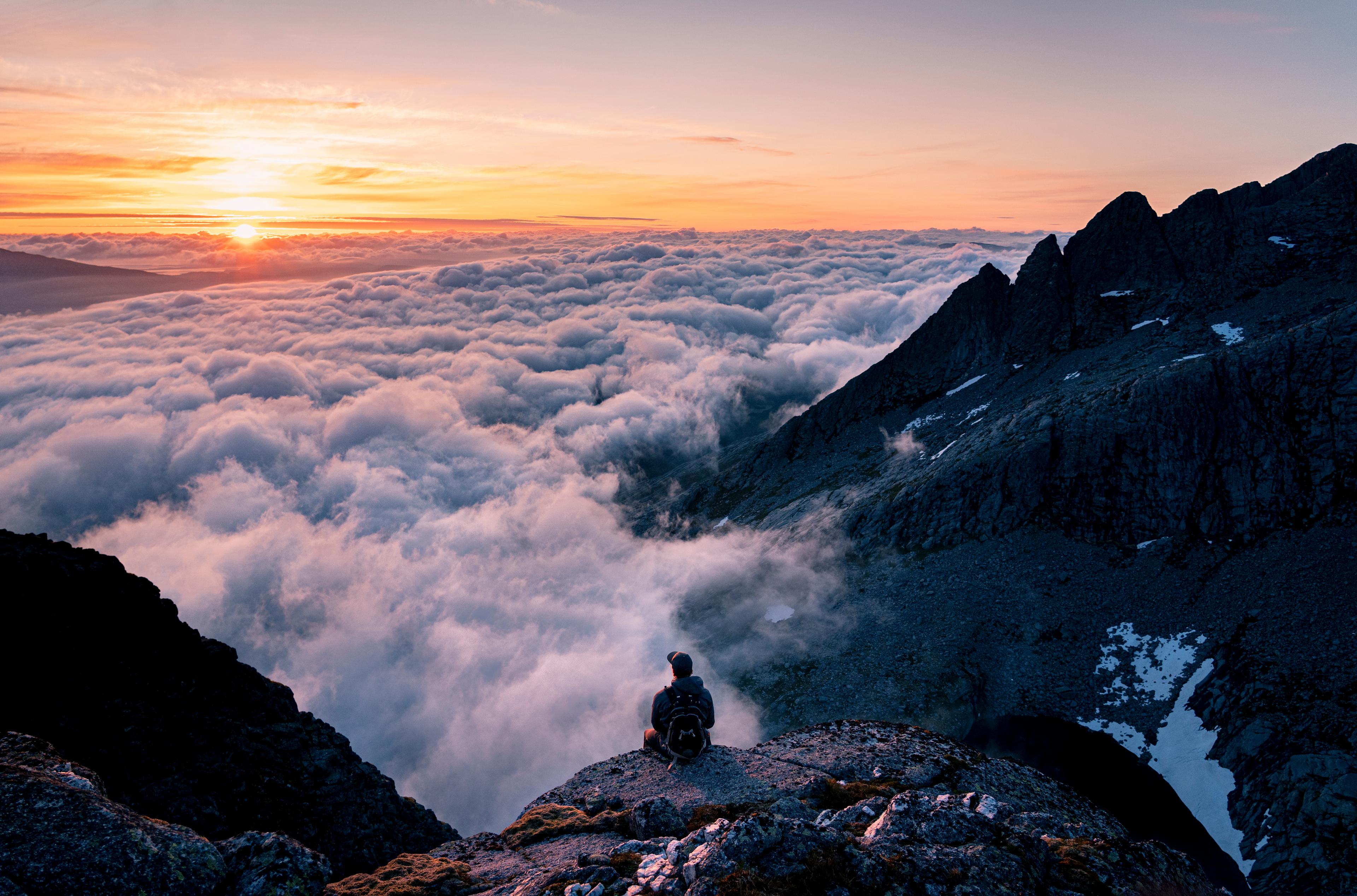 Person sitting at the top of the seven sisters hike in Gryfoten, Northern Norway