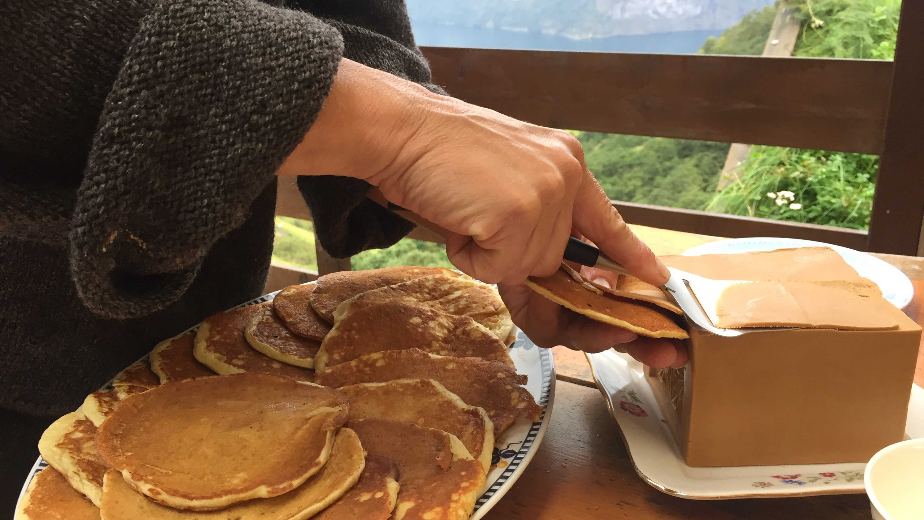 Person slicing brown cheese for pancakes