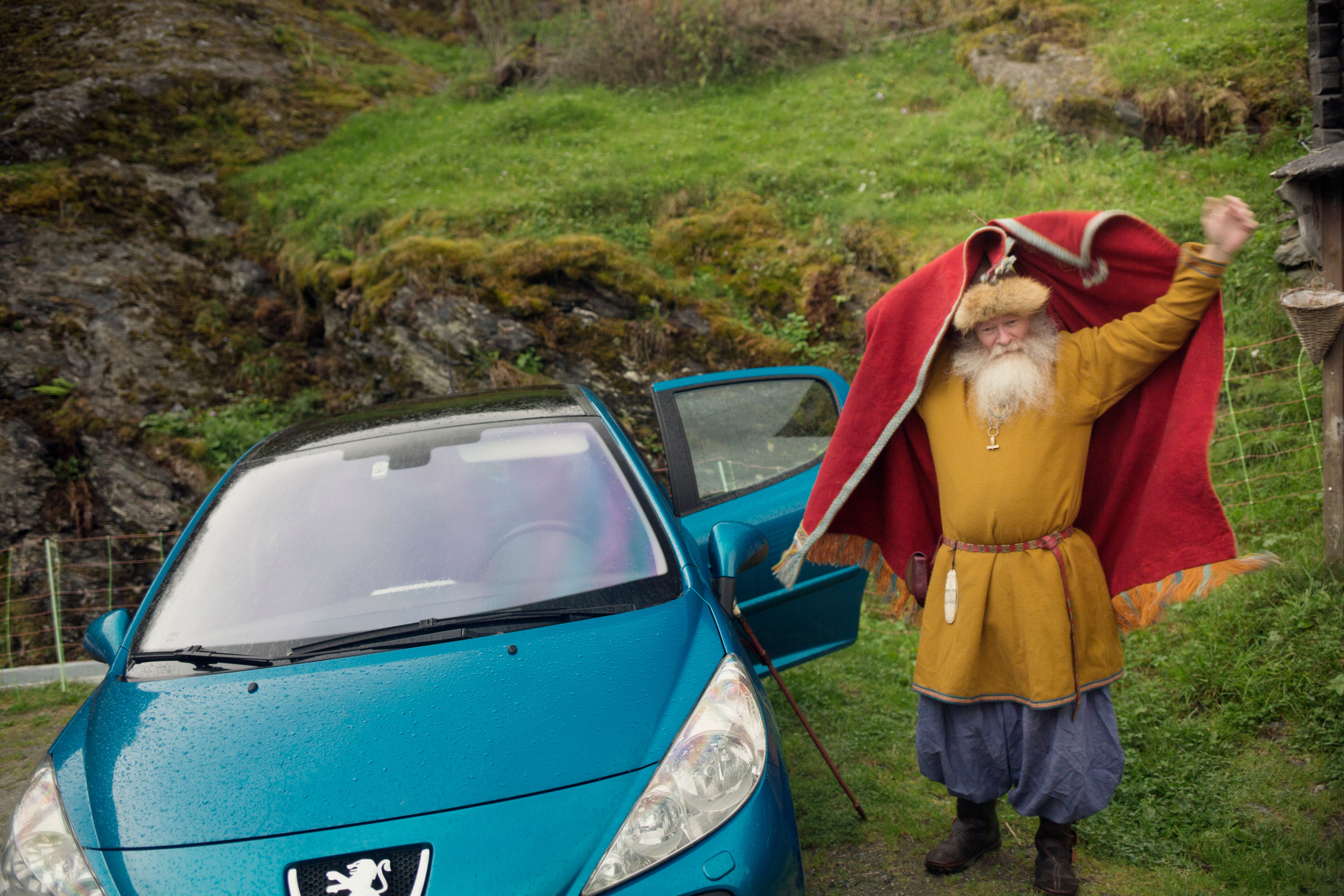 Olafr Reydarsson next to his car, putting on his cloak