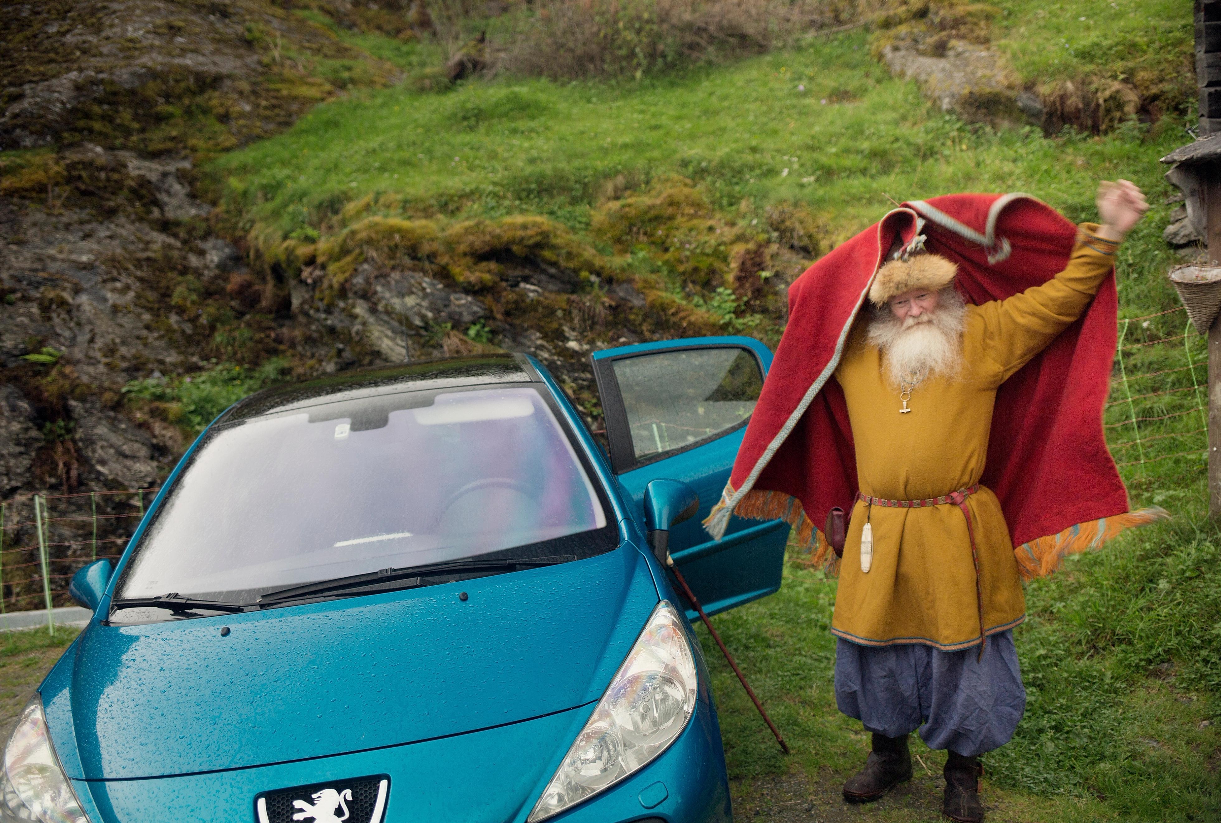 Olafr Reydarsson next to his car, putting on his cloak