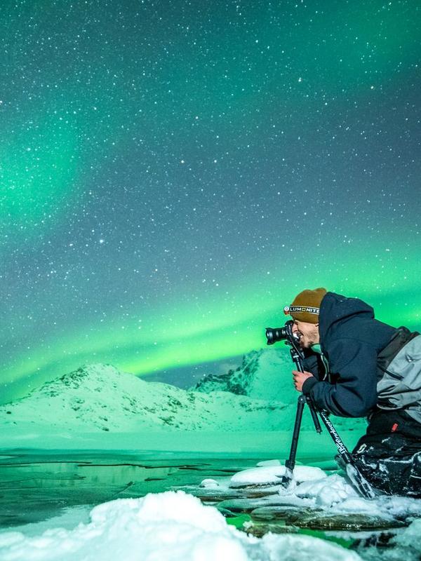 Person taking picture of the northern lights in Northern Norway