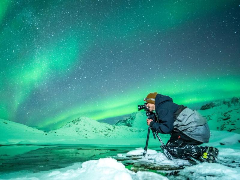Person taking picture of the northern lights in Northern Norway