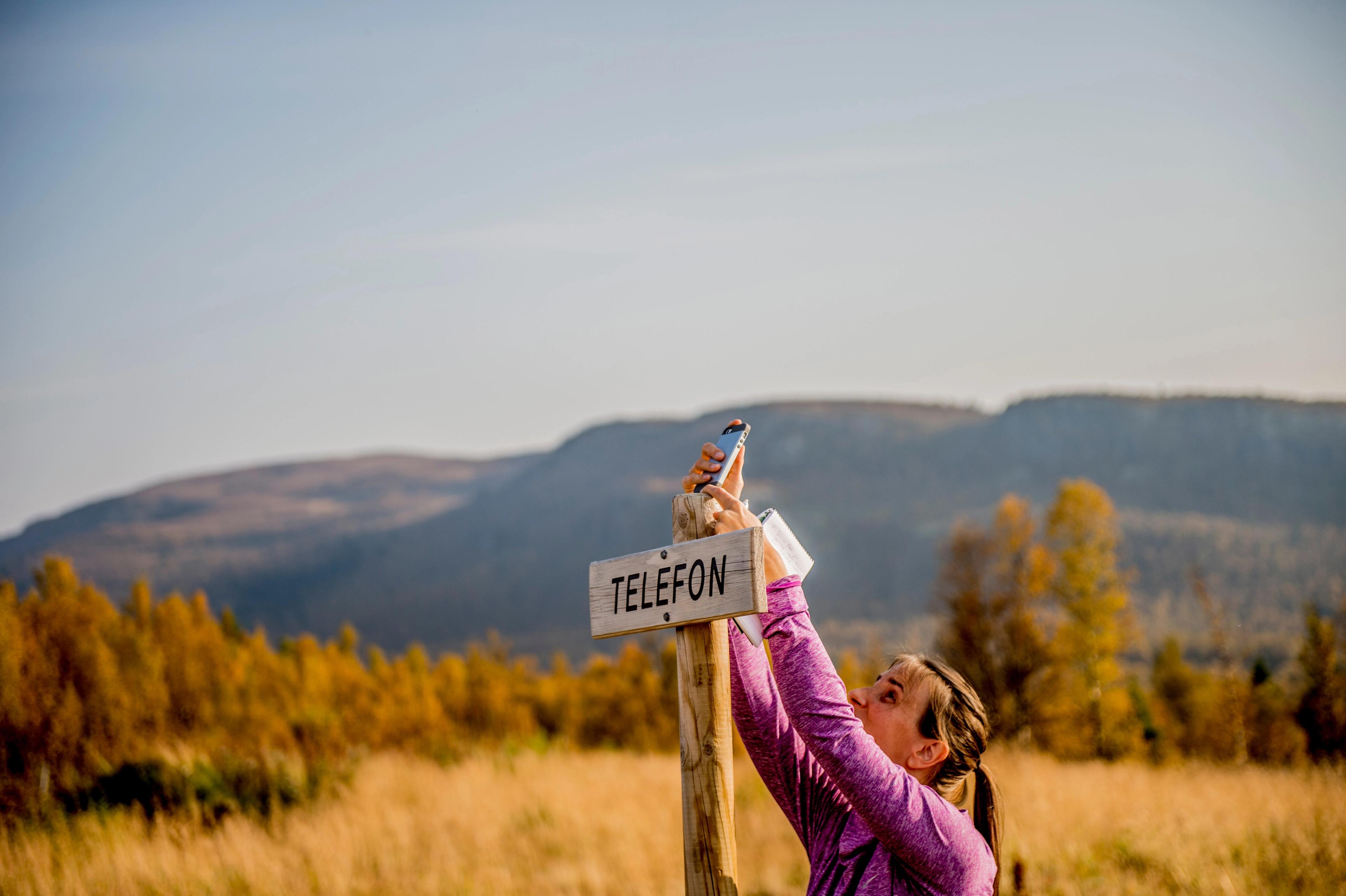 A person holding a cellphone in Langsua national park, Eastern Norway