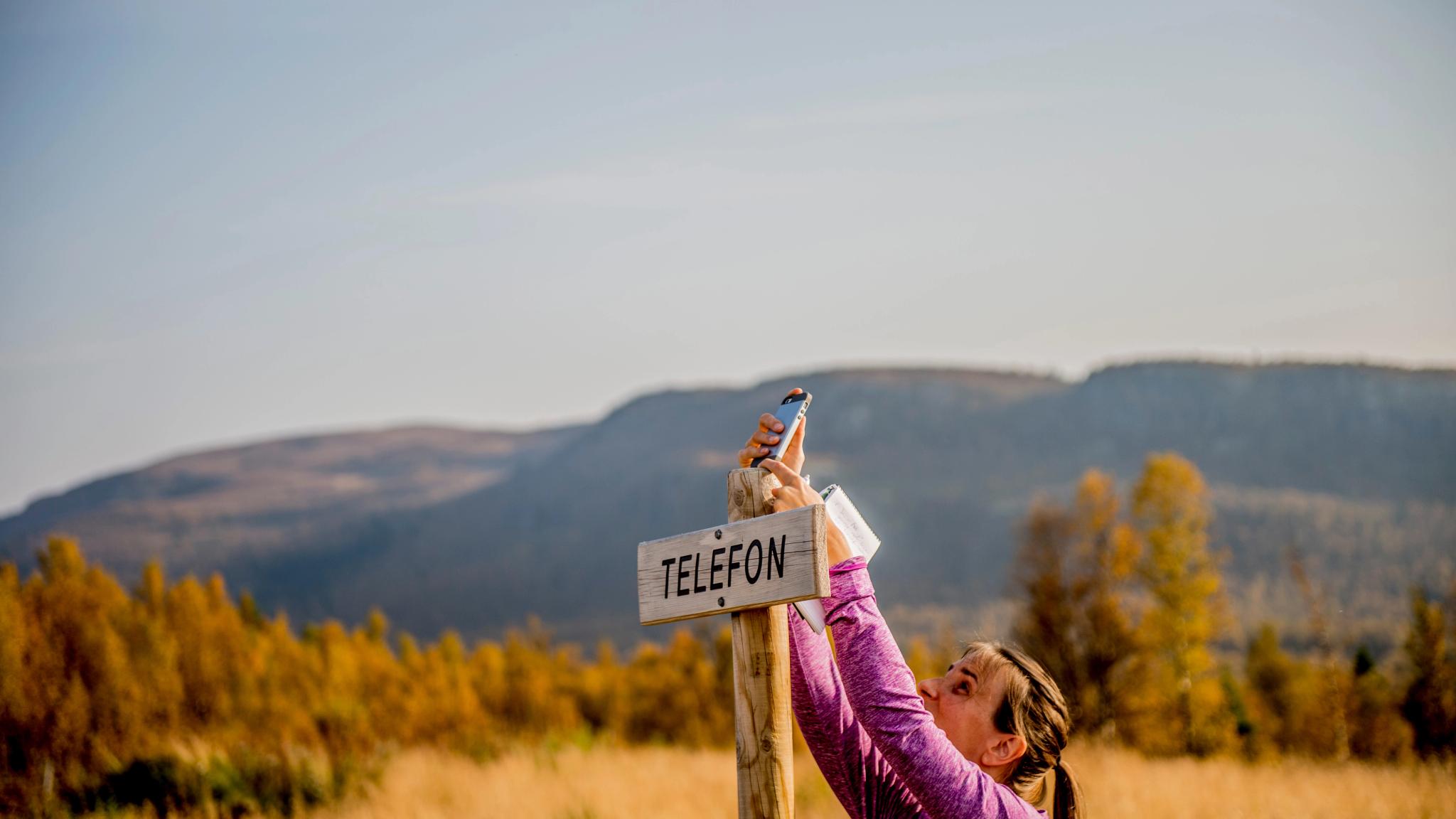 A person holding a cellphone in Langsua national park, Eastern Norway