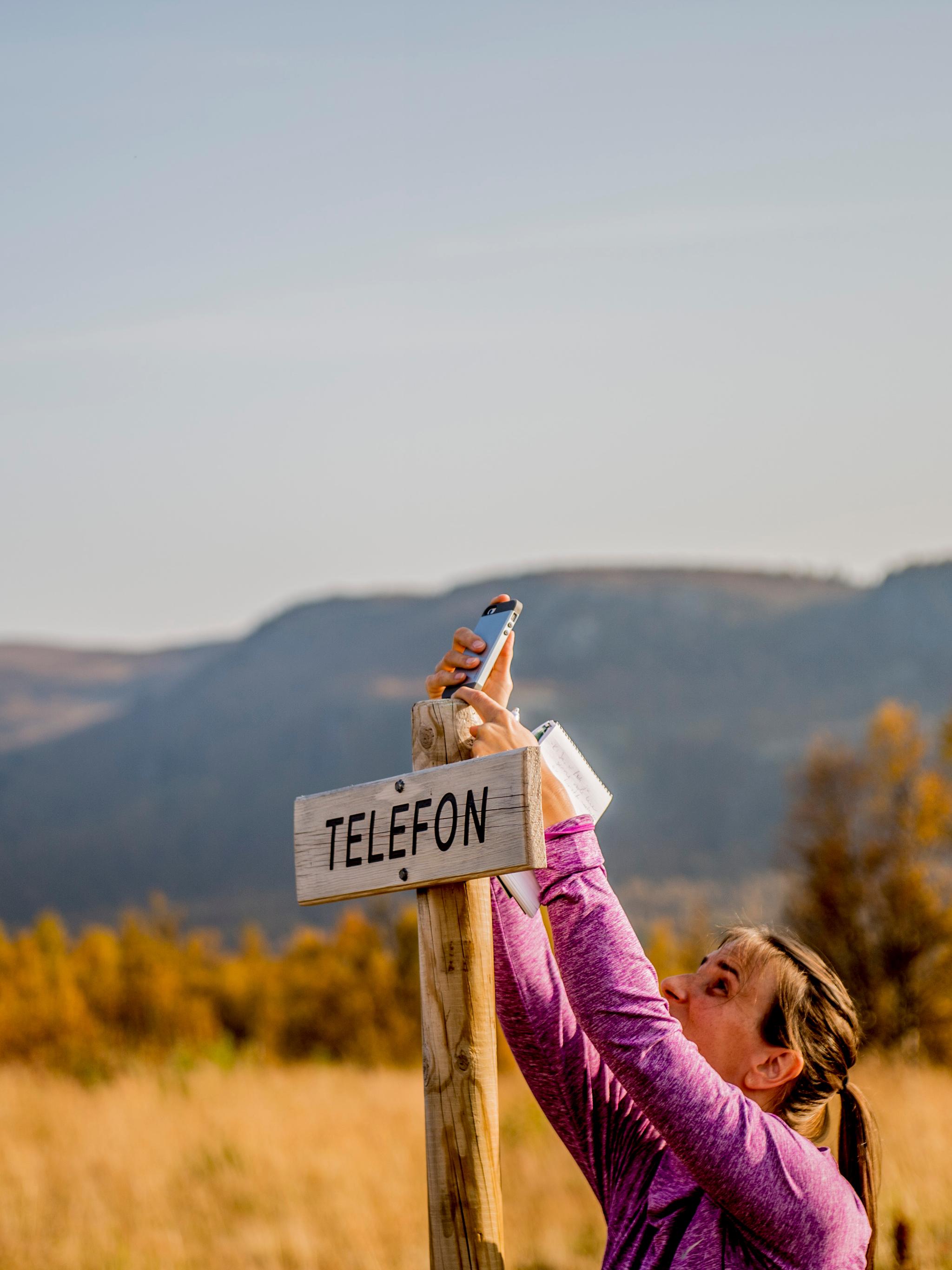 A person holding a cellphone in Langsua national park, Eastern Norway