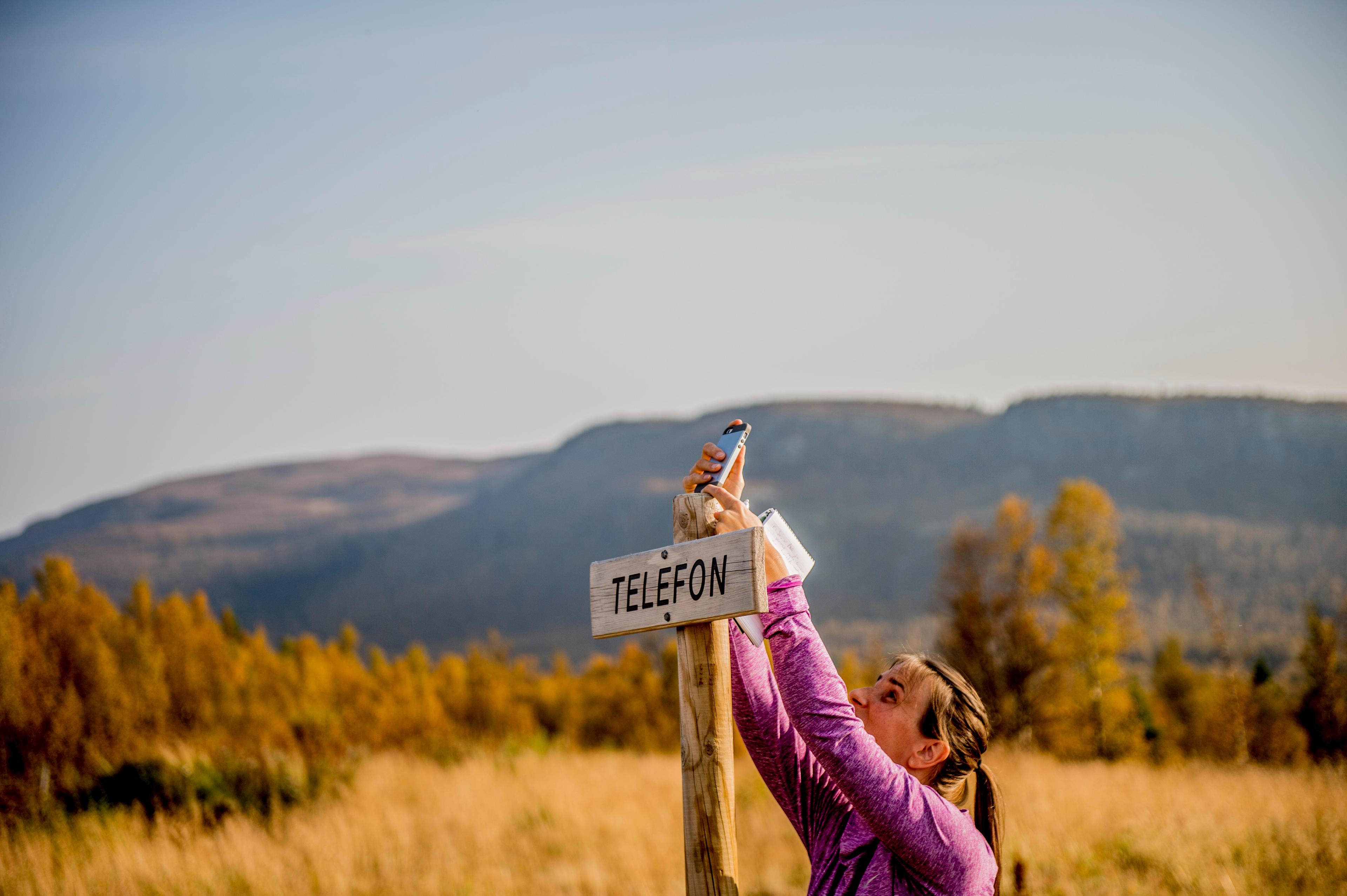 A person holding a cellphone in Langsua national park, Eastern Norway