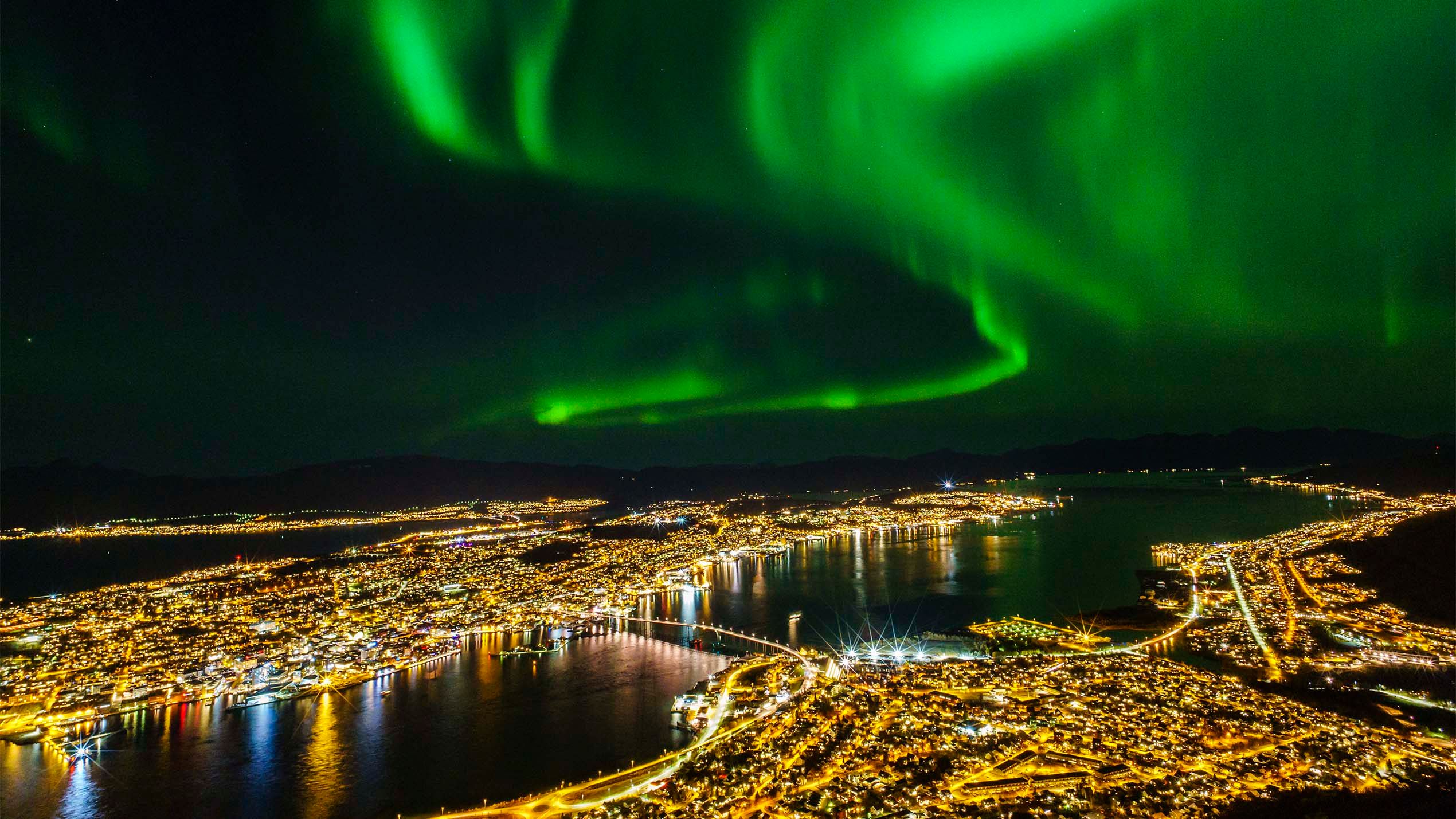 The northern lights are dancing on the sky above Tromsø in Northern Norway