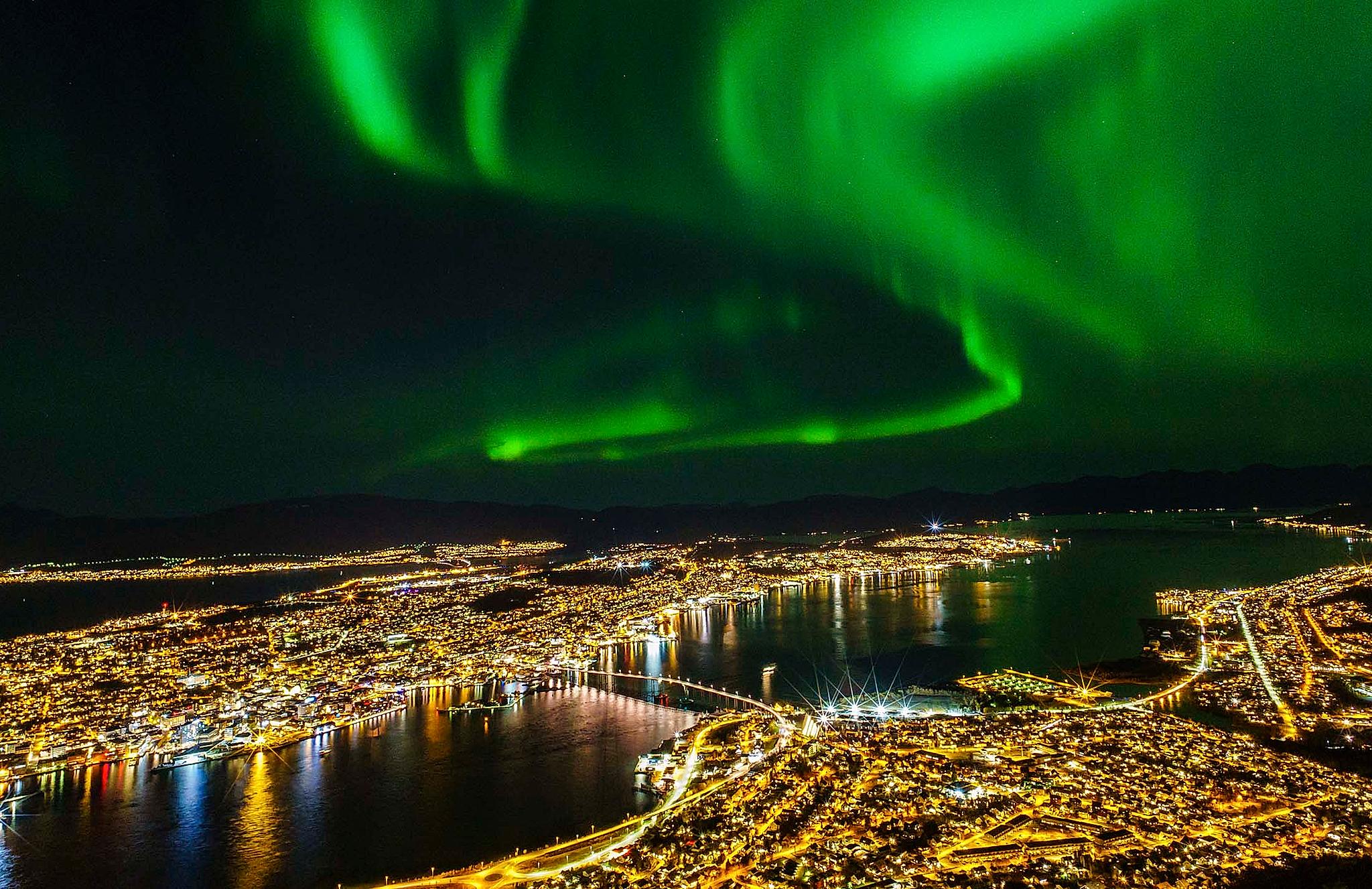 The northern lights are dancing on the sky above Tromsø in Northern Norway