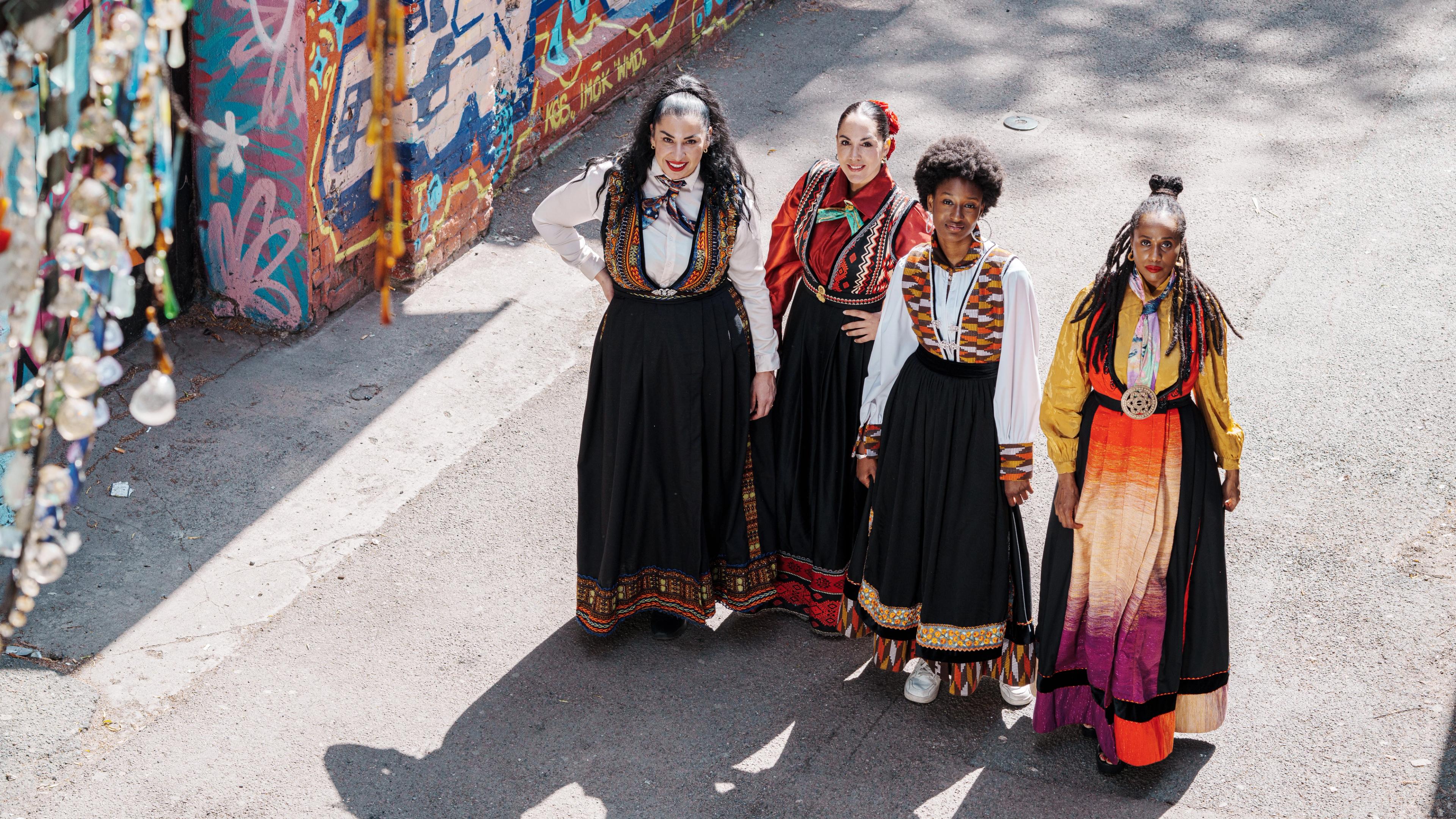 Fire damer i fargerike festdrakter