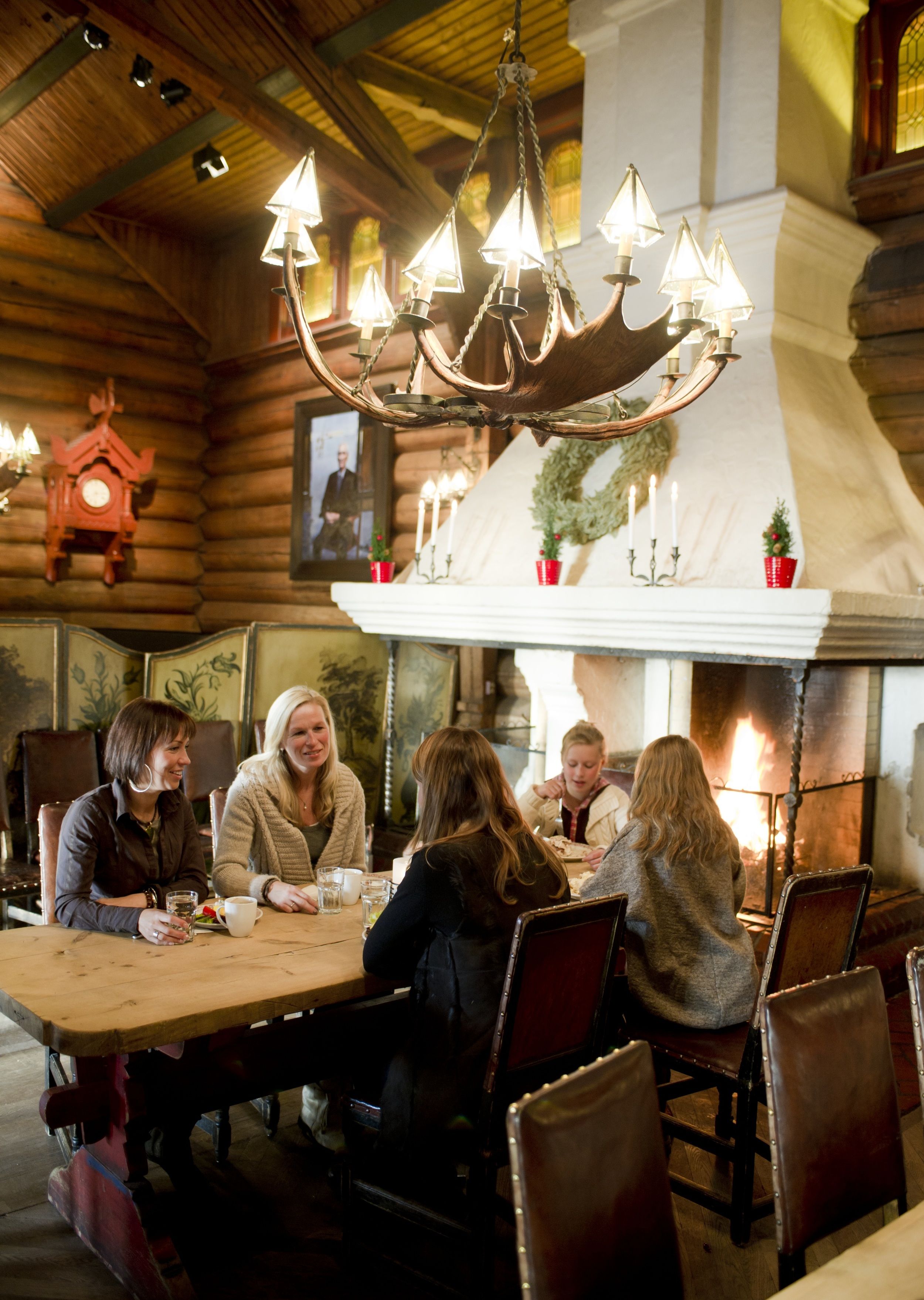 People eating by the fireplace at Frognerseteren restaurant in Oslo