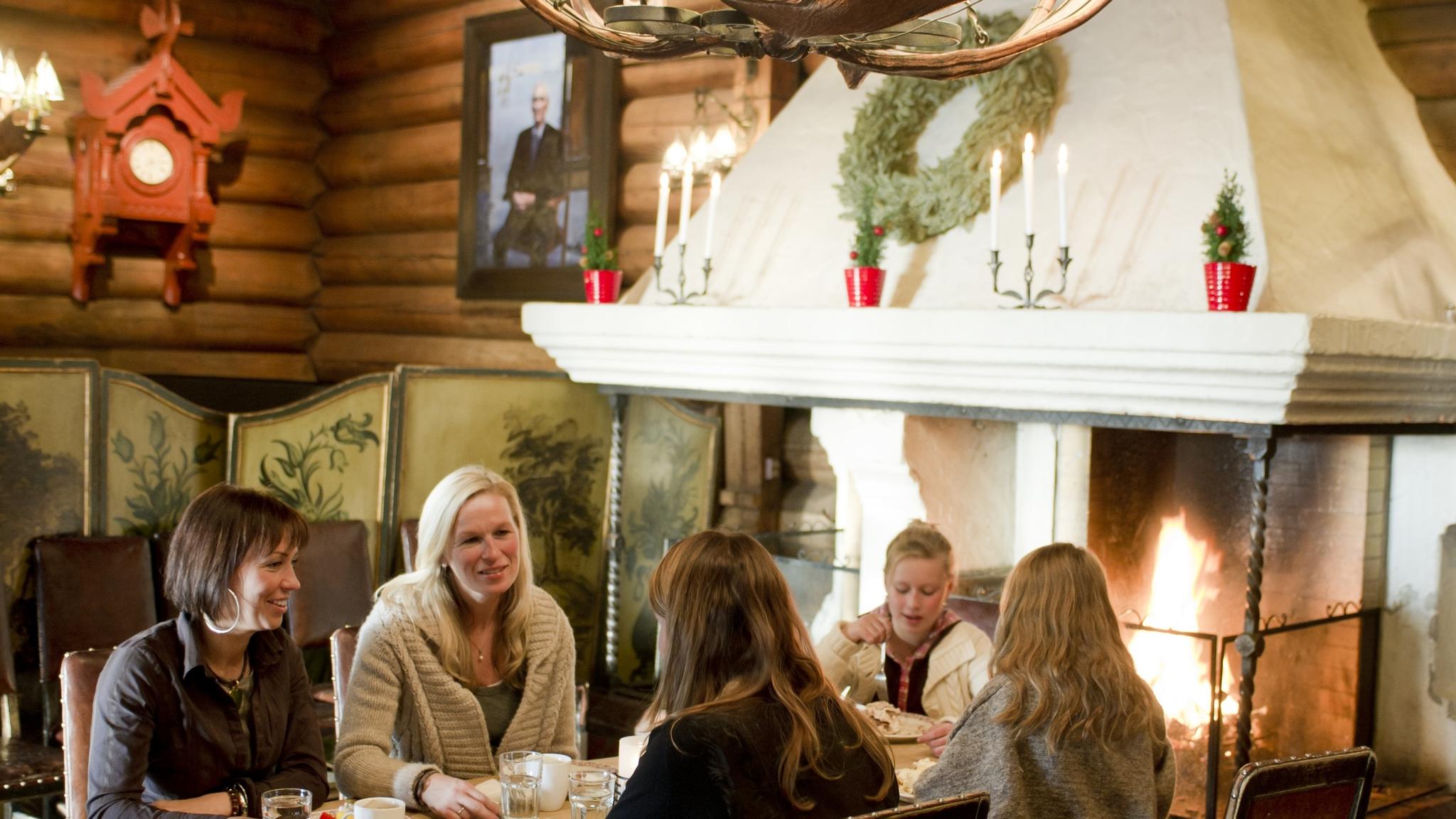 People eating by the fireplace at Frognerseteren restaurant in Oslo