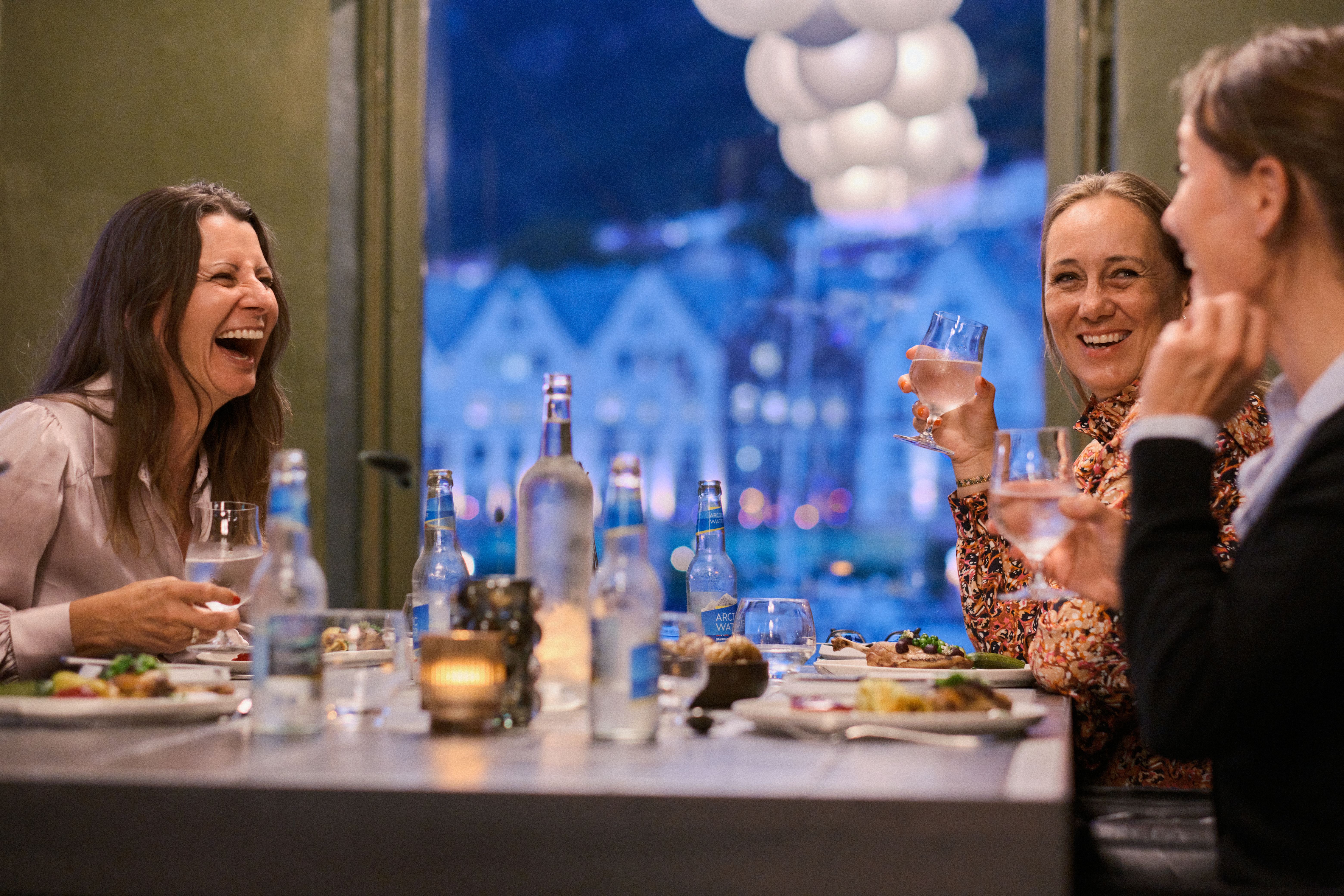 Four women enjoying dinner during menopause vacation in Norway