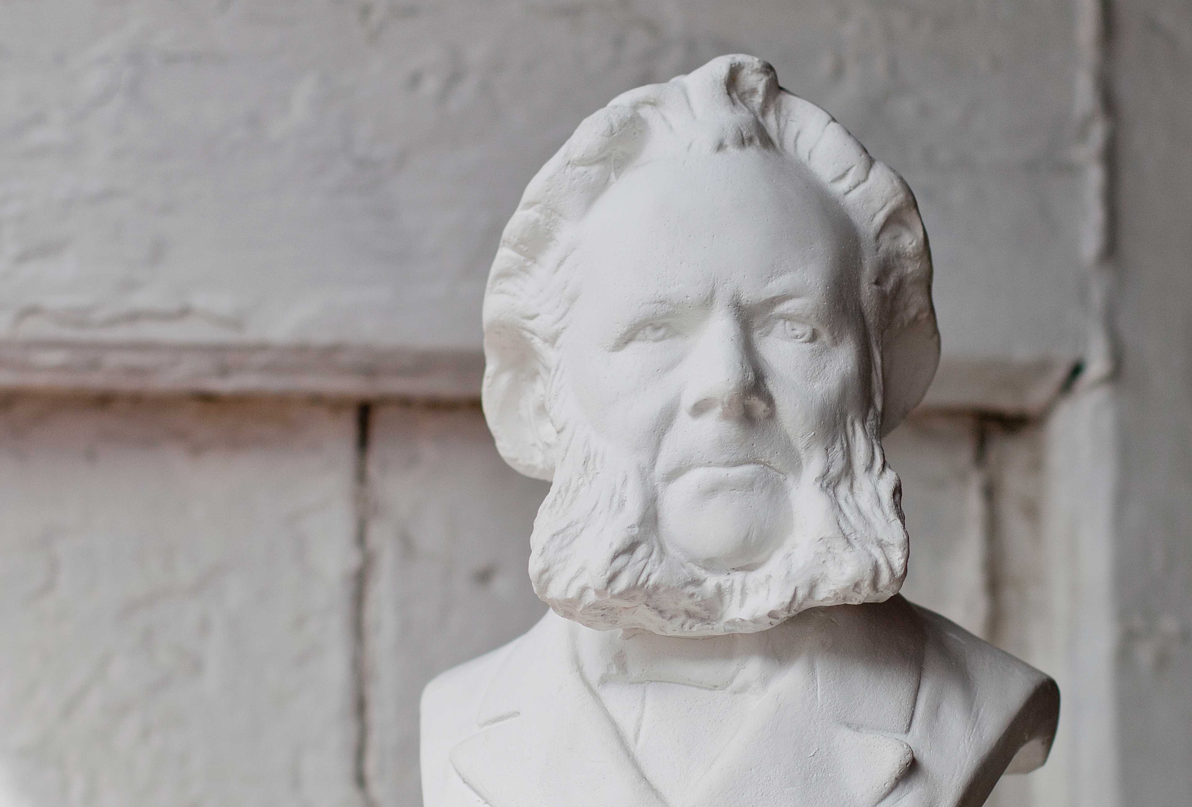 Hands holding up a white bust of Henrik Ibsen. Grimstad, Southern Norway.