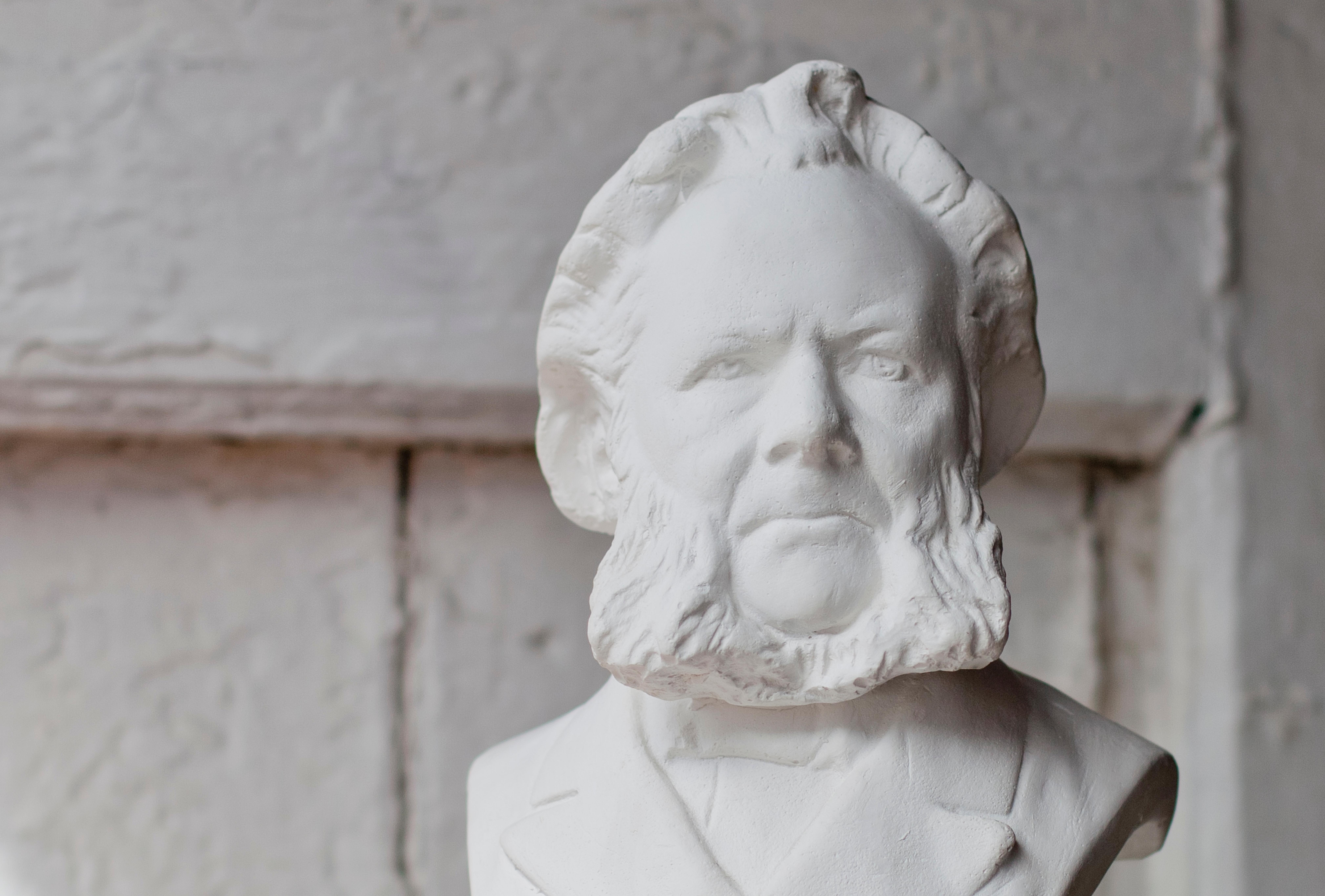 Hands holding up a white bust of Henrik Ibsen. Grimstad, Southern Norway.