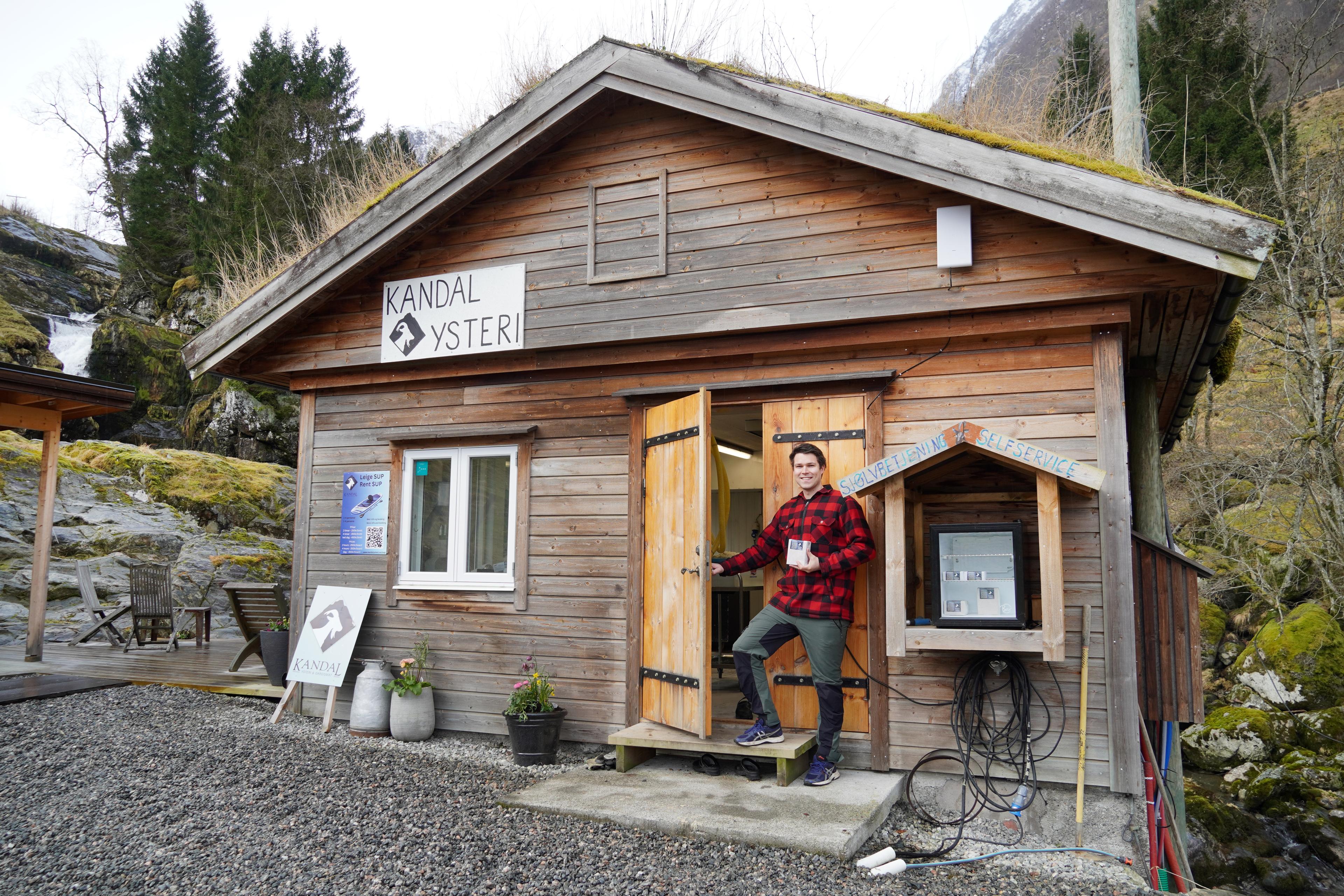 A man standing outside a self service brown cheese shop in Kandal in gloppen in Western Norway.