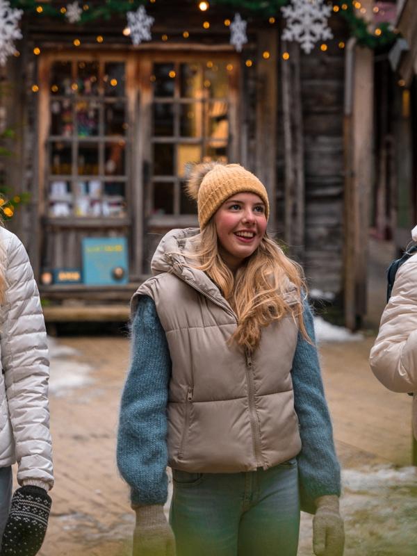 Three girls walking between the Christmassy wooden houses in Bergen, Fjord Norway