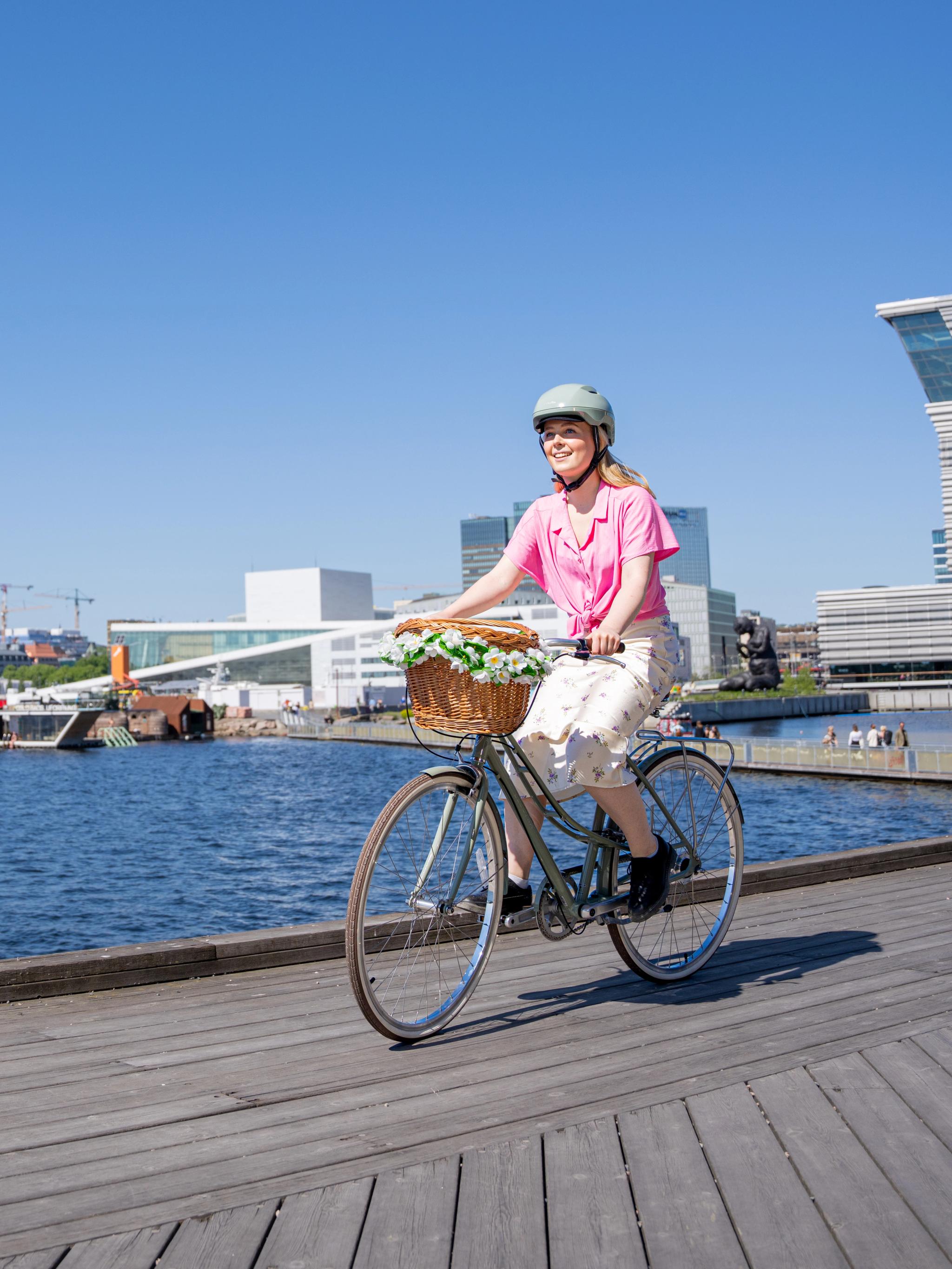 A girl cycling along the harbour in Oslo