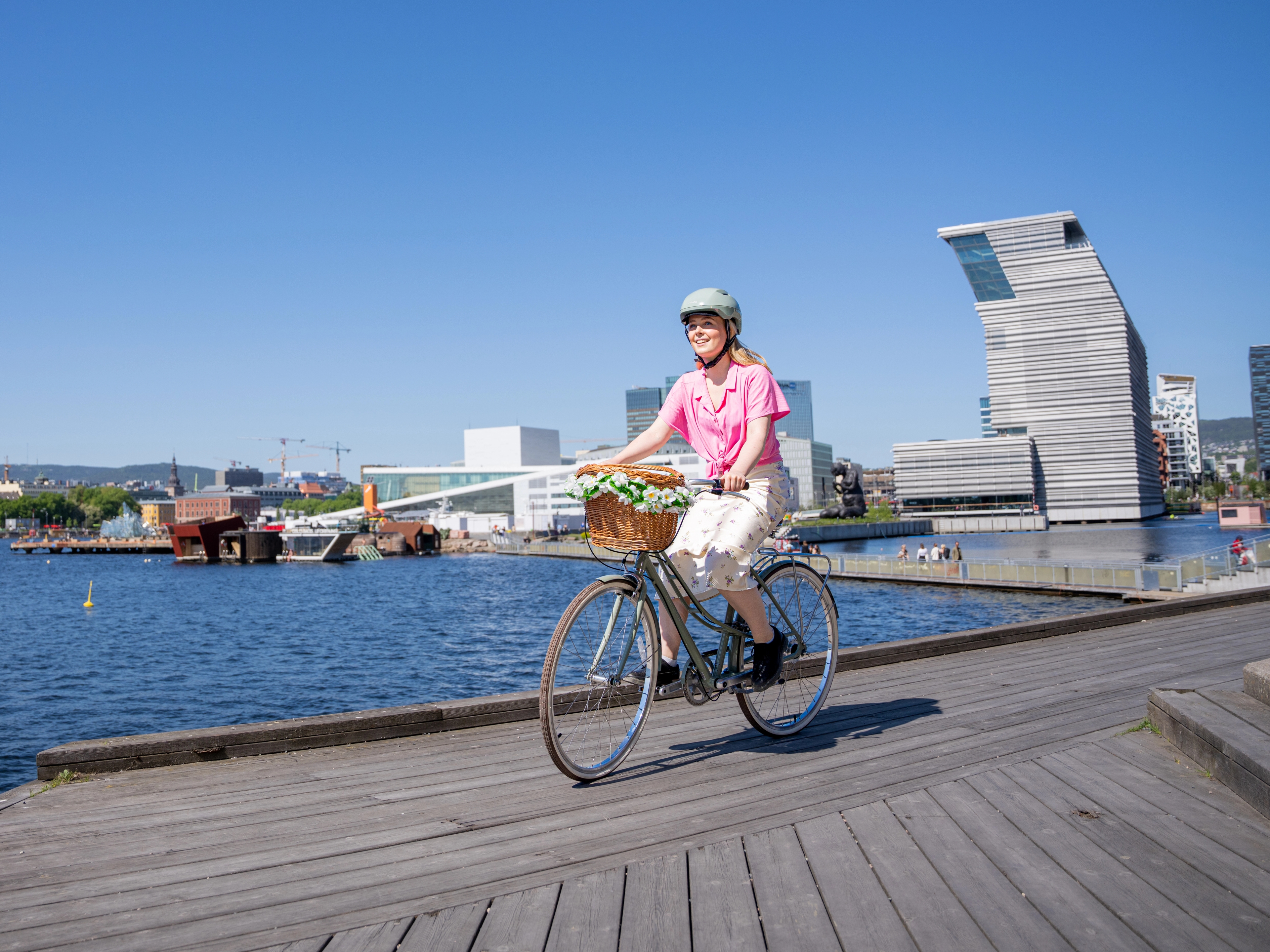 A girl cycling along the harbour in Oslo
