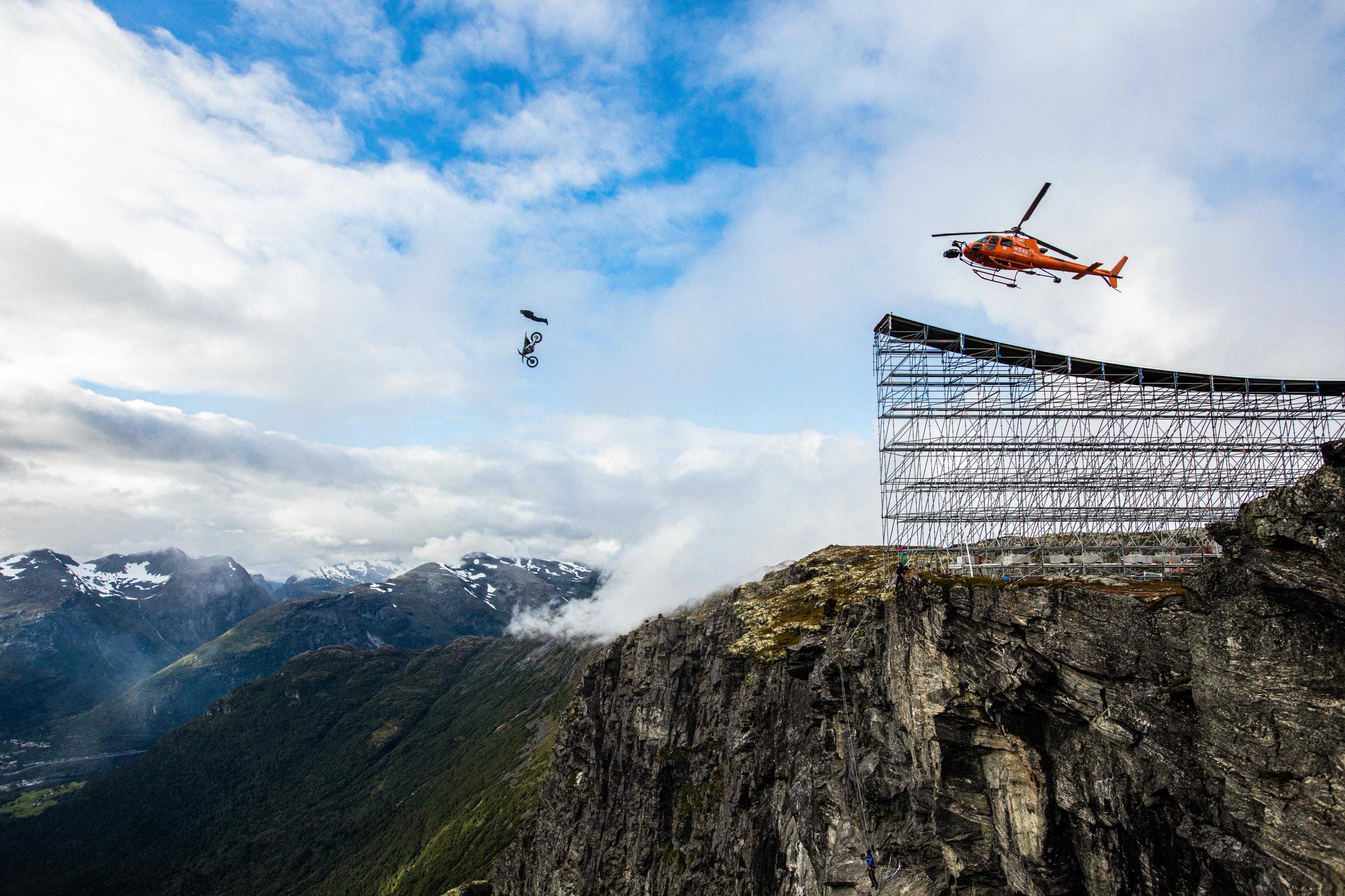 Tom Cruise performing an epic stunt jumping off a cliff into a base jump at Helsetkopen in Fjord Norway