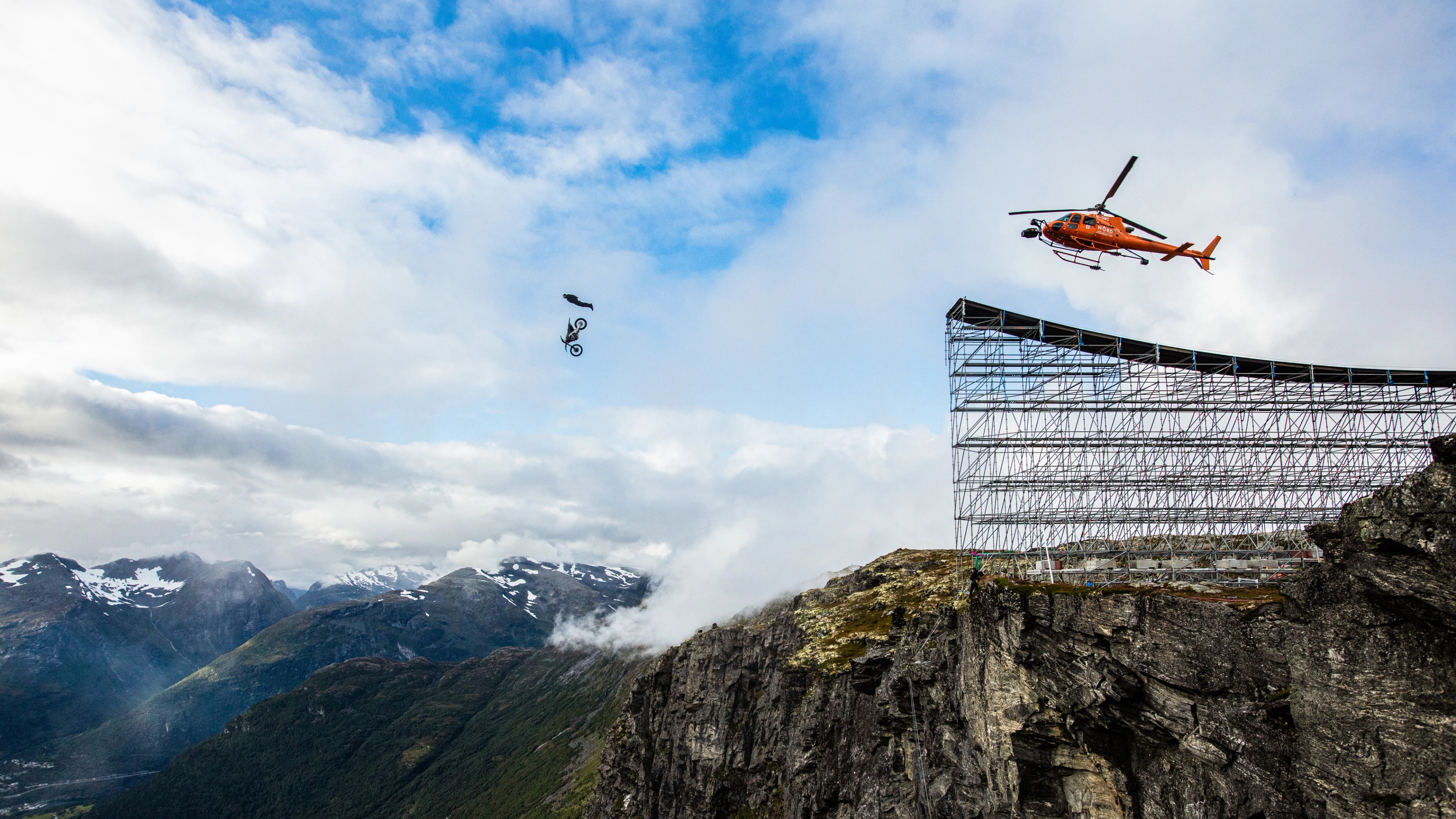 Tom Cruise performing an epic stunt jumping off a cliff into a base jump at Helsetkopen in Fjord Norway