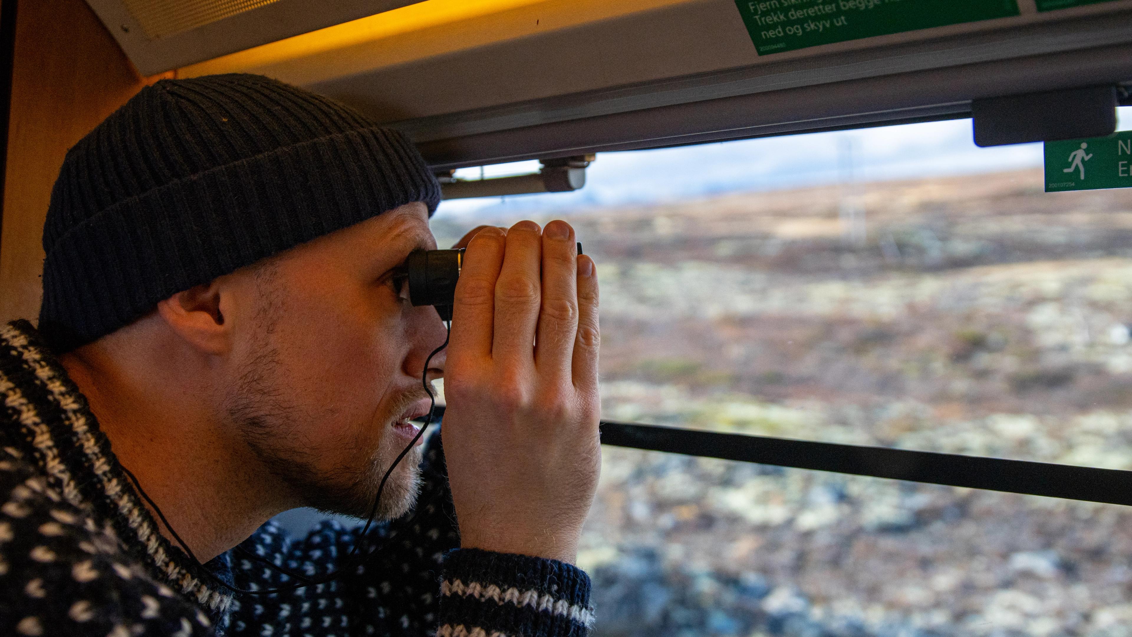 A man looking at the view from the Dovre Railway train