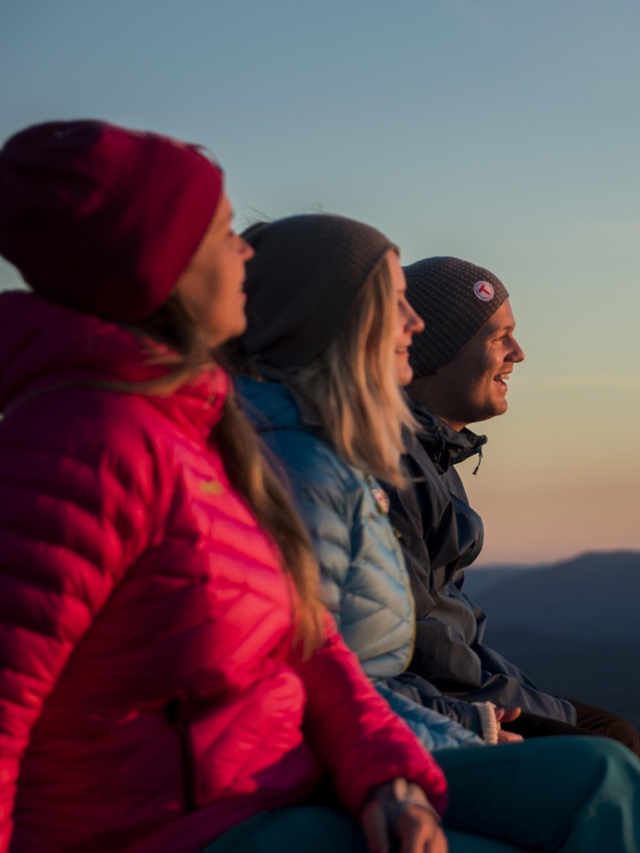 Three people enjoying the view from Mount Gaustatoppen in Telemark, Eastern Norway