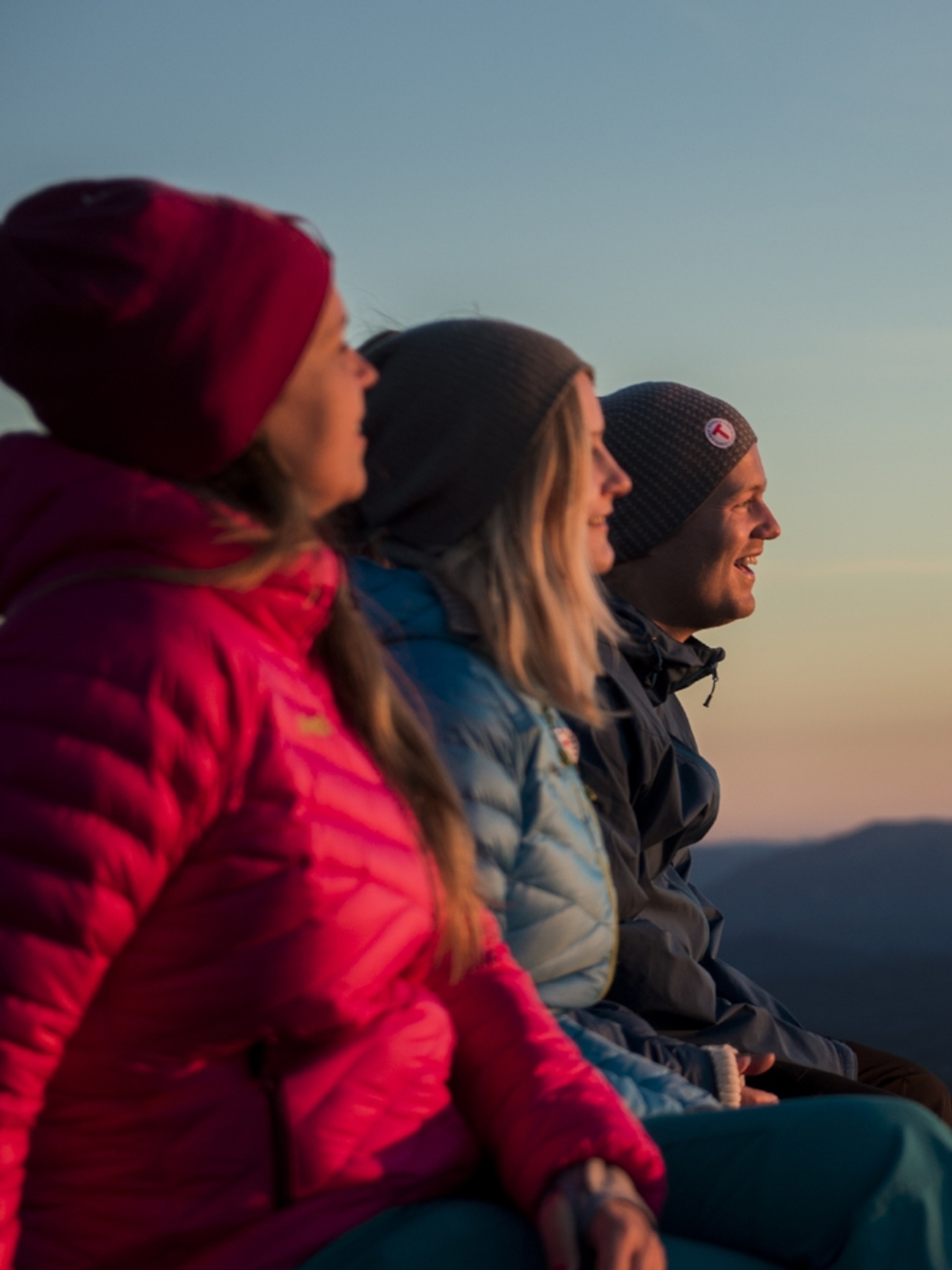 Three people enjoying the view from Mount Gaustatoppen in Telemark, Eastern Norway