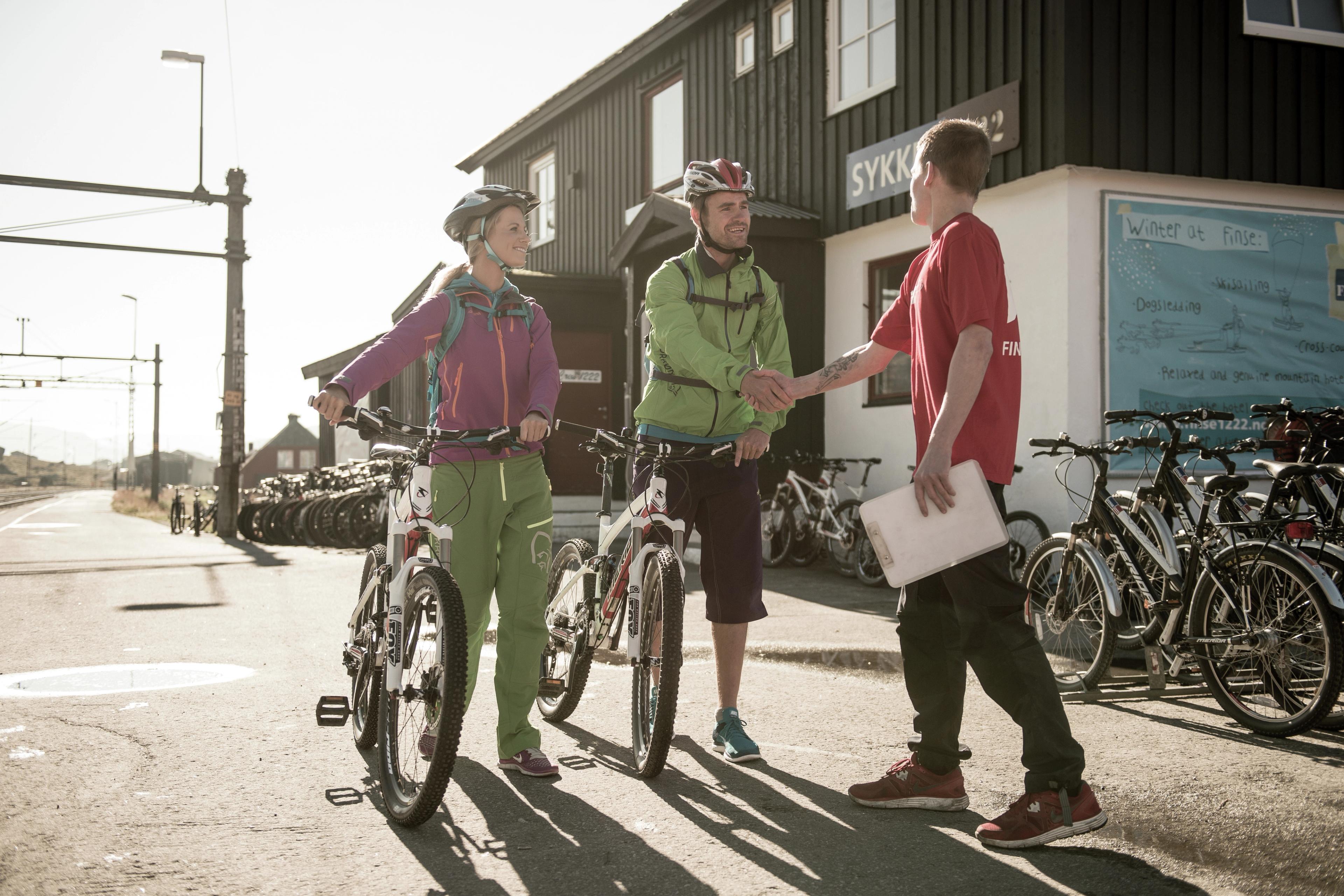 To turcyklister står klar til at cykle Rallarvegen ved cykeludlejningen i Finse, Norge