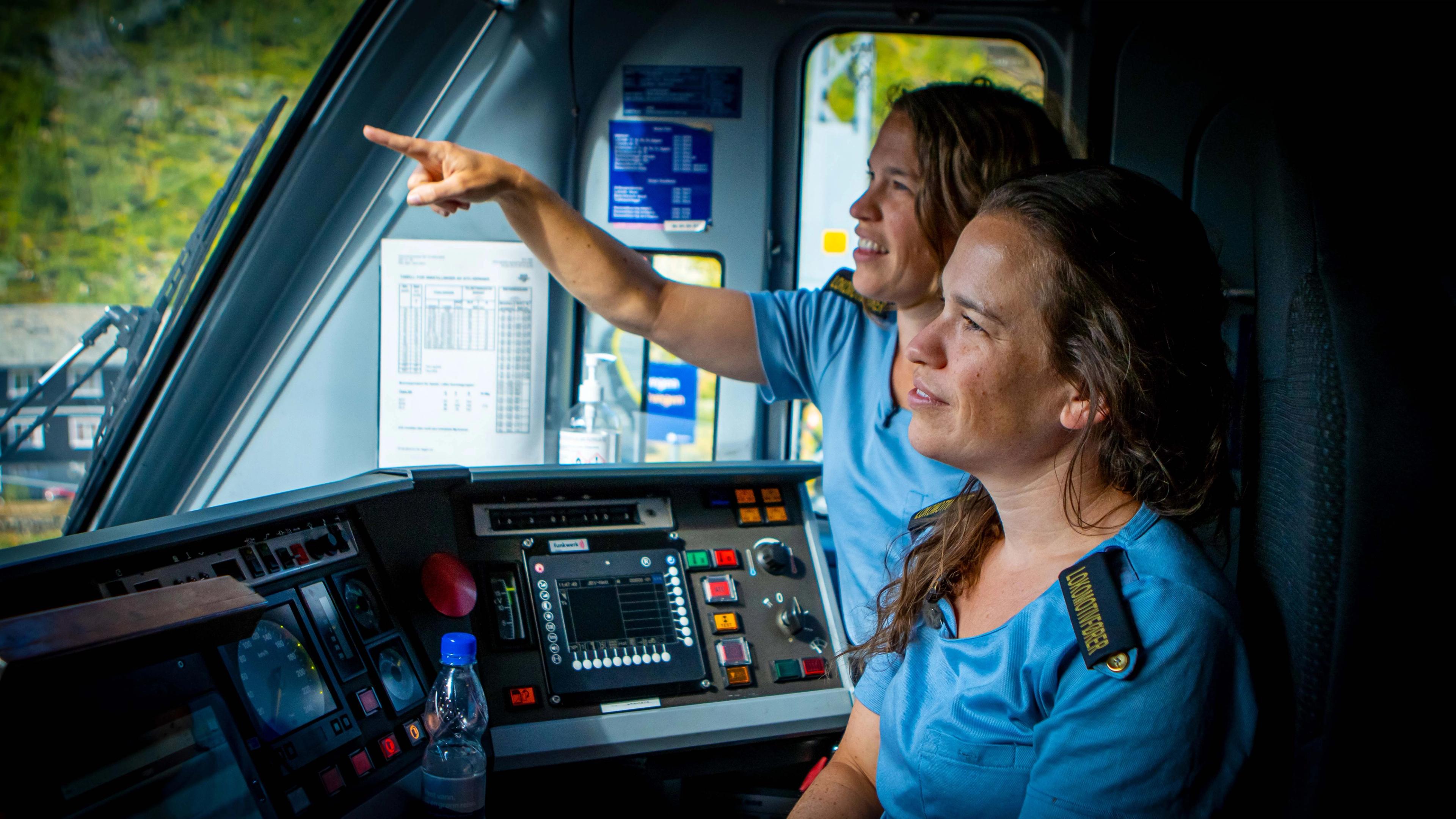 Two train drivers sitting in the train.
