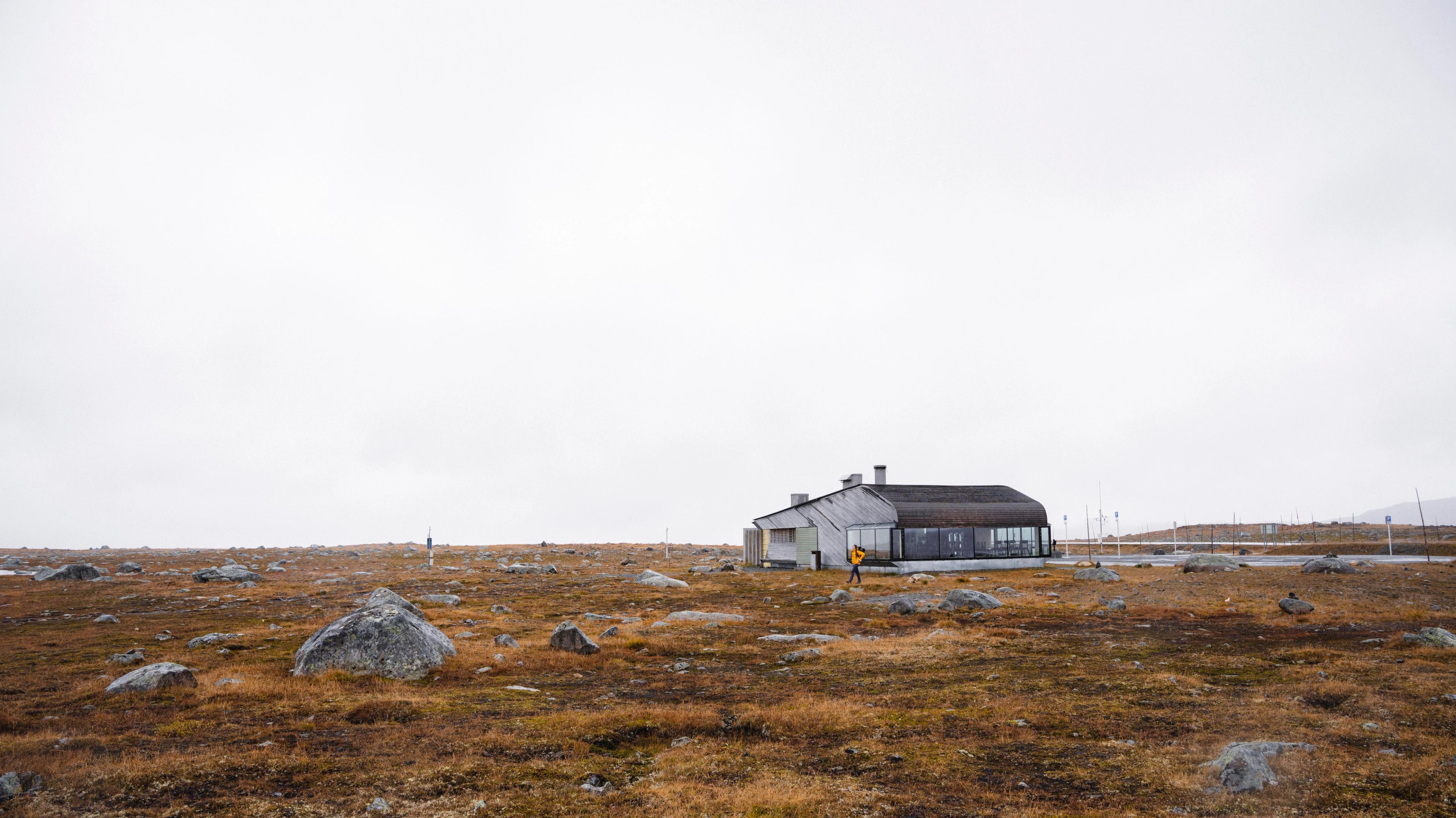 A woman hiking outside of Valdresflye Café in autumn.