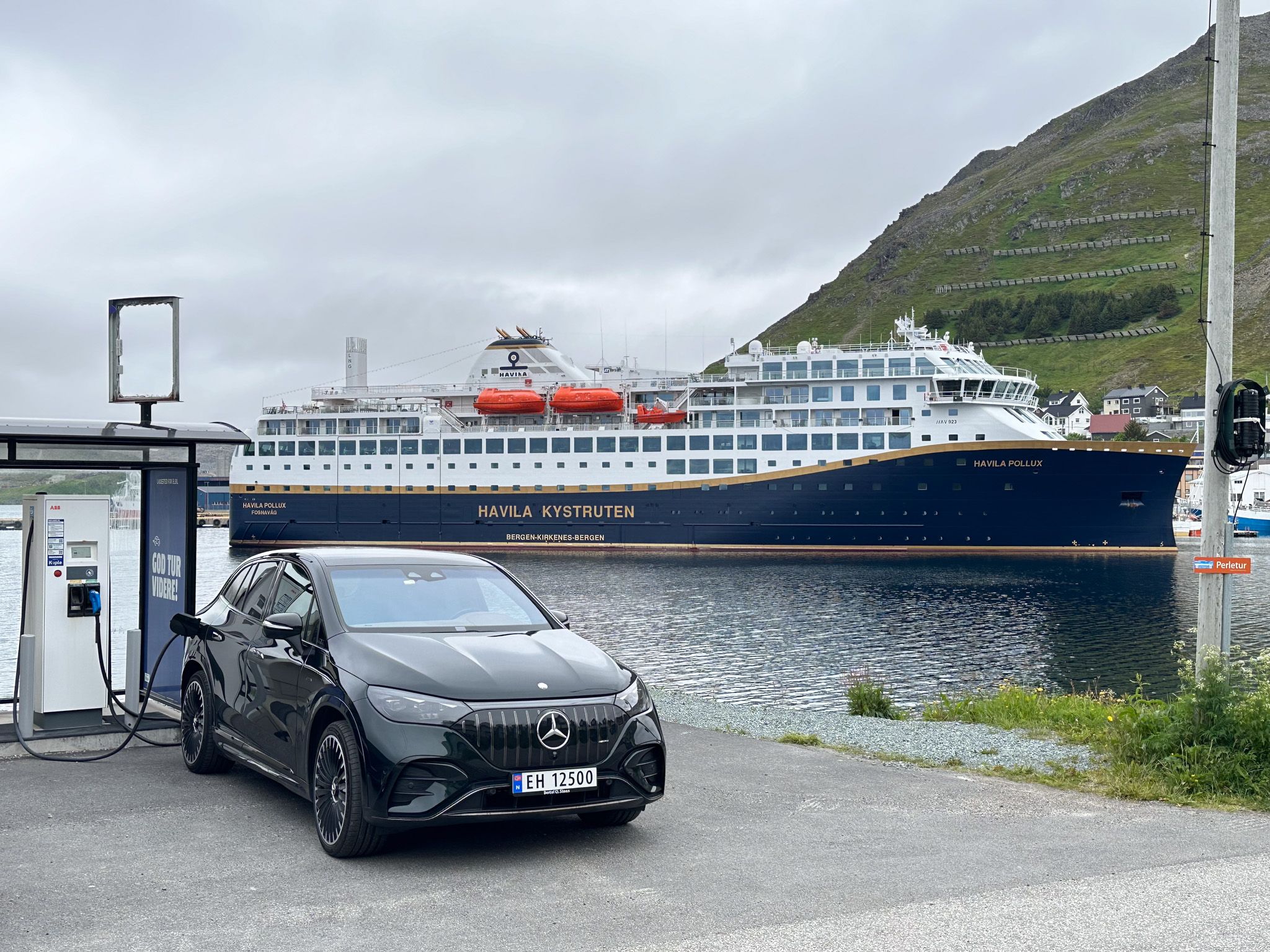 An electric car charging in front of a Havila ship