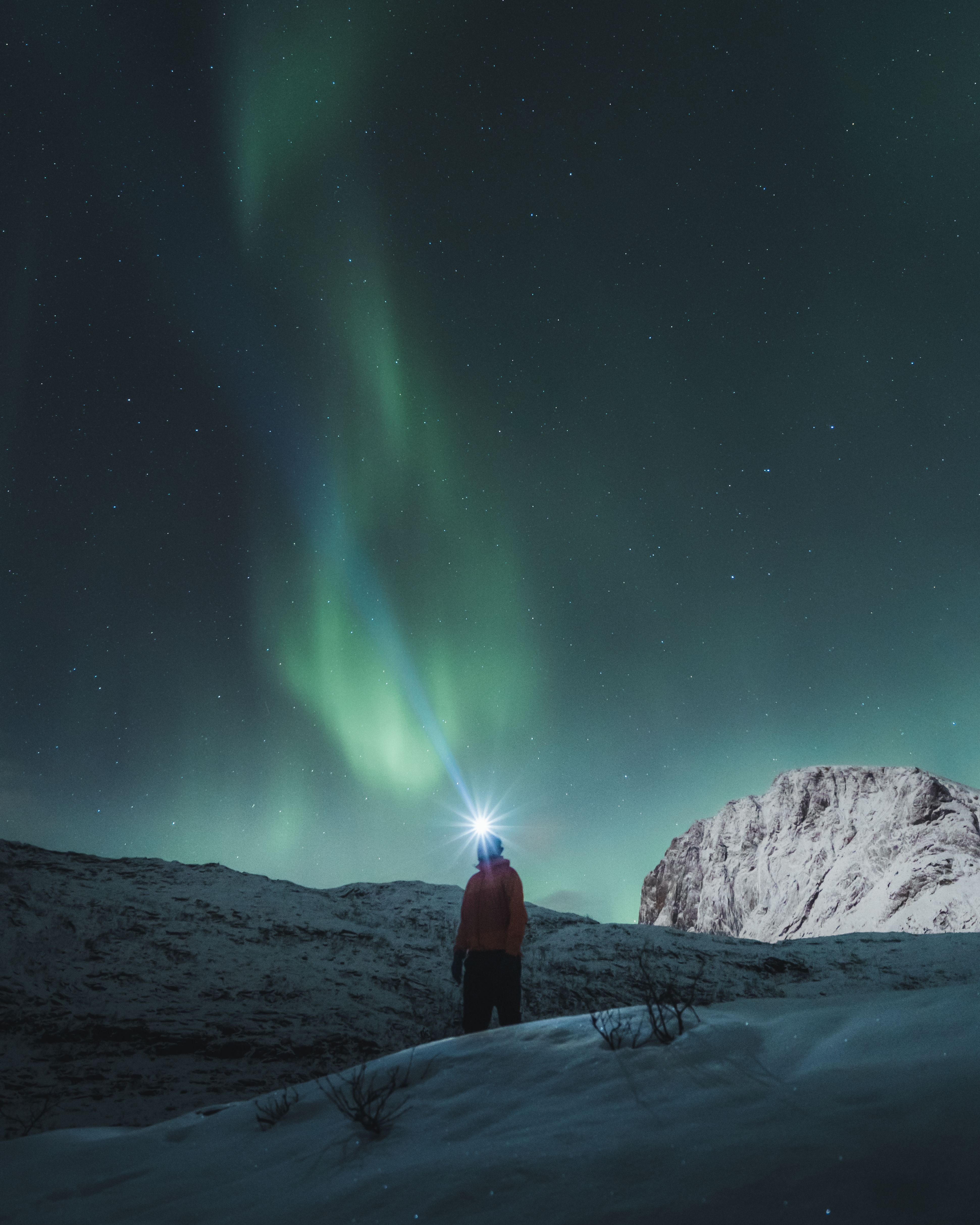 Man watching the northern lights over Mefjordsletta, Senja