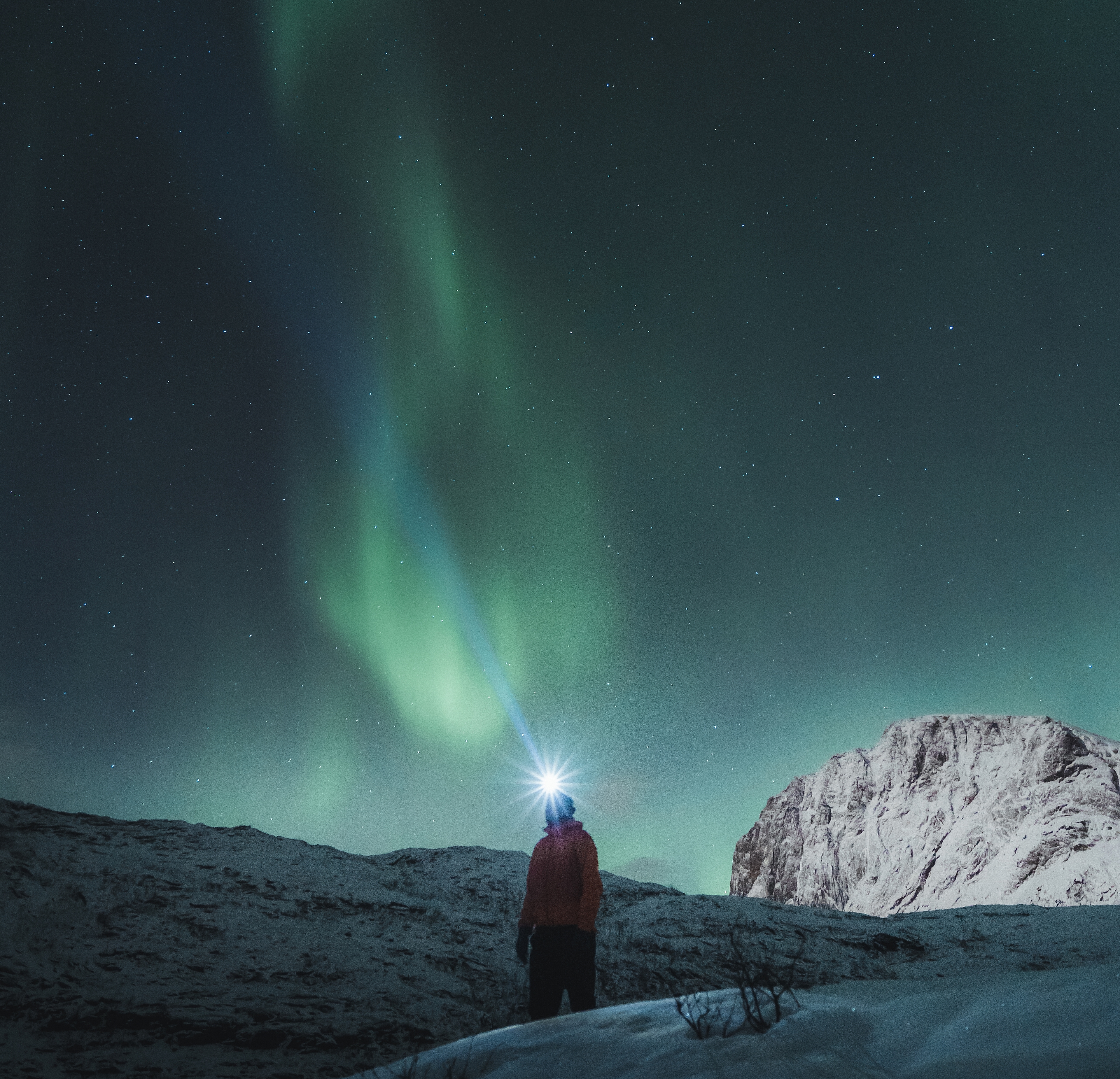 Man watching the northern lights over Mefjordsletta, Senja