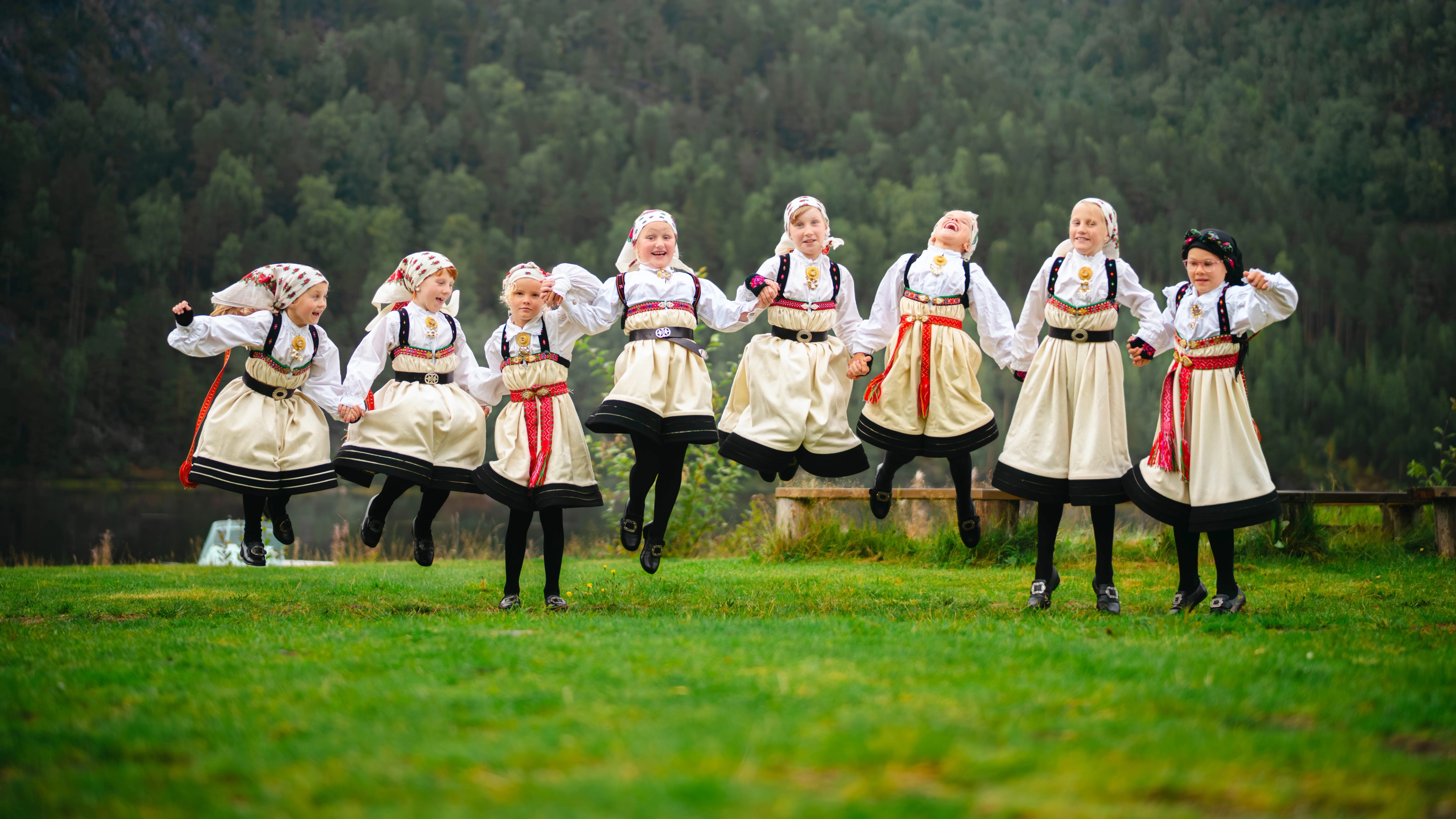 Jenter i Setesdalsbunad hopper av glede